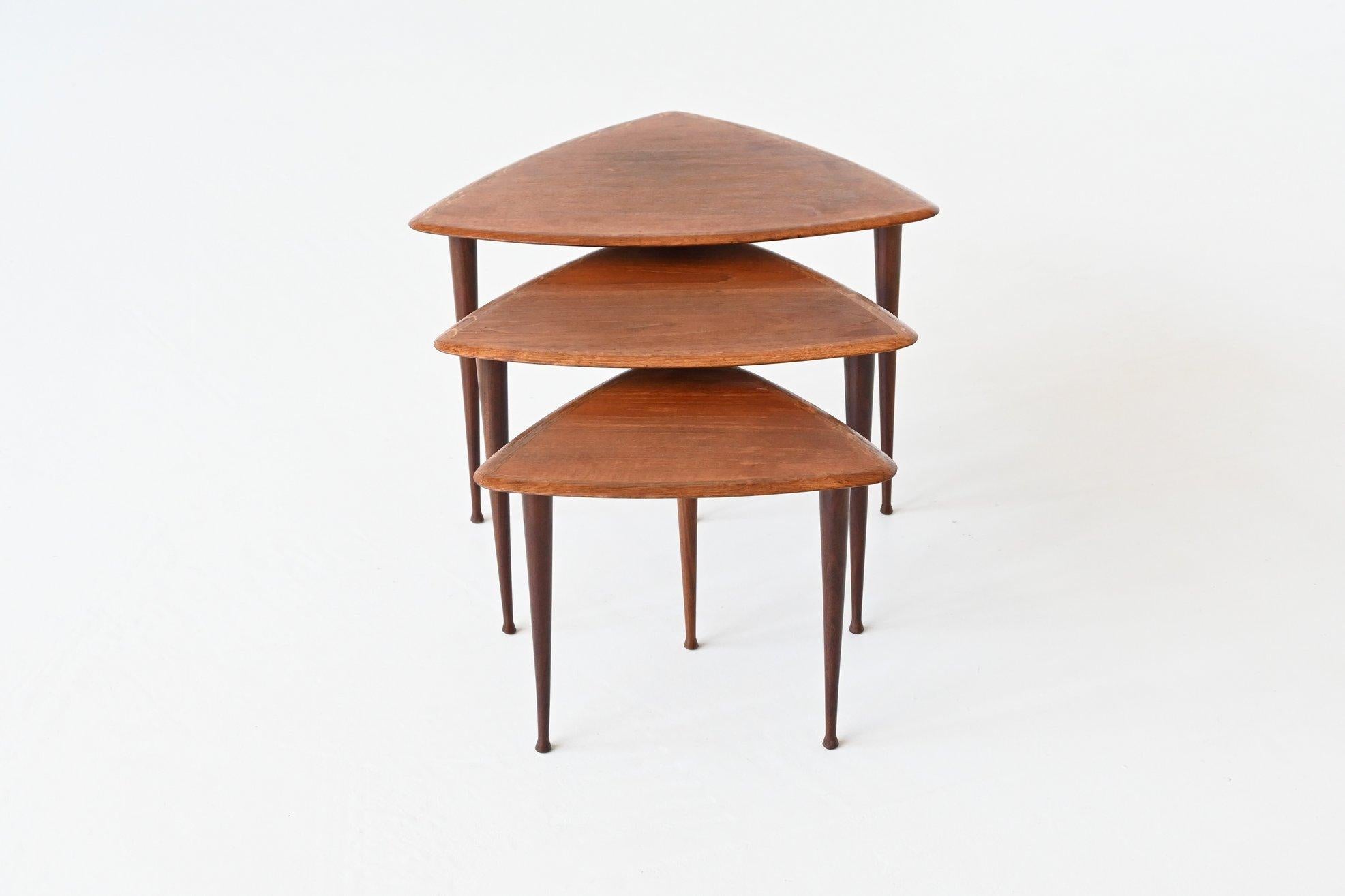 Beautiful shaped set of three nesting tables in the manner of Poul Jensen by Selig, Denmark 1960. These very nice triangle shaped tables are made of teak wood, the feet are solid and the tops are veneered. They give a minimalist look due to the