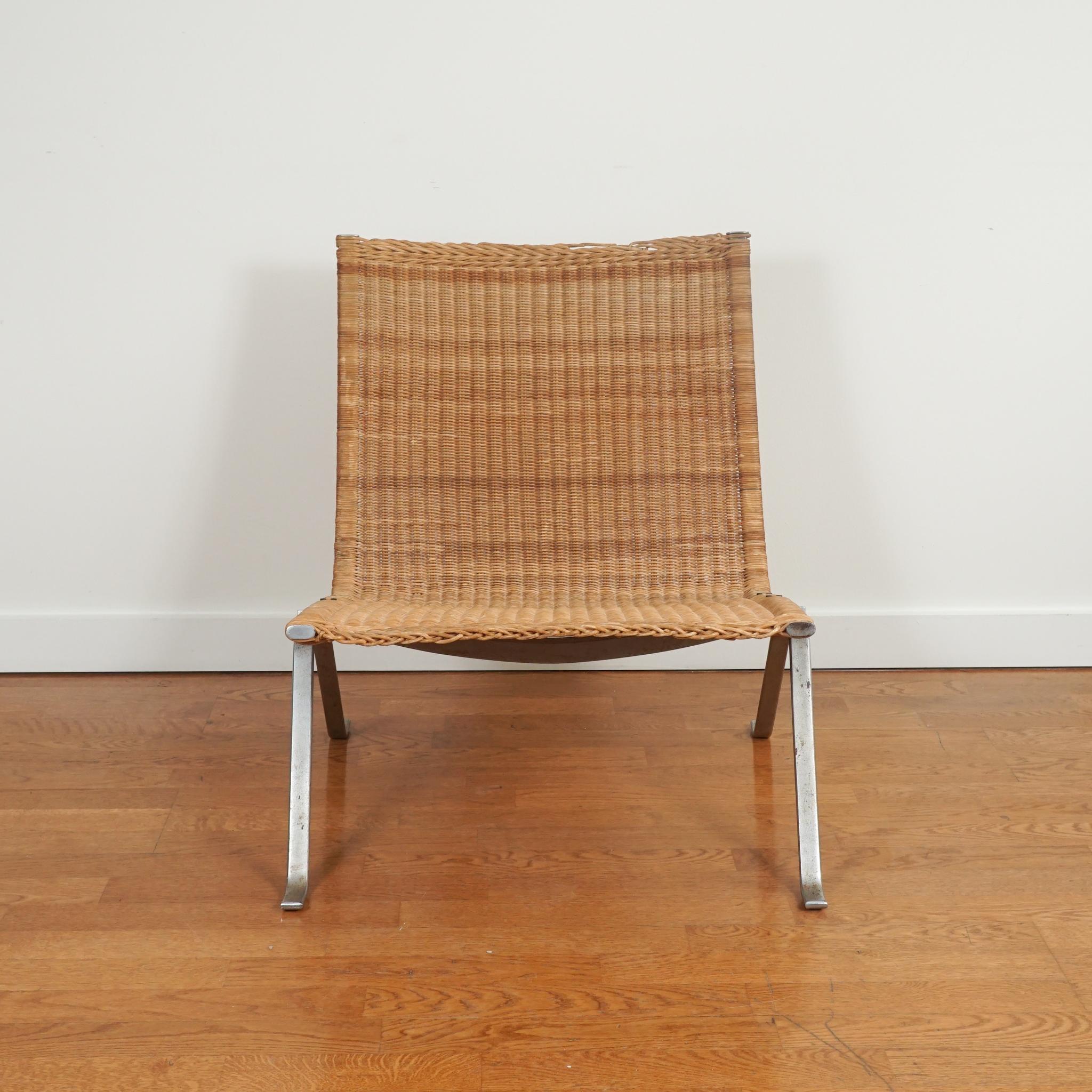 Highly recognizable and extremely desirable is this Poul Kjaerholm PK 22 wicker and stainless lounge chair—one of two available. Made with wicker and brushed steel, the chair by Poul Kjaerholm for E. Kold Christensen was designed 1951. Two chairs