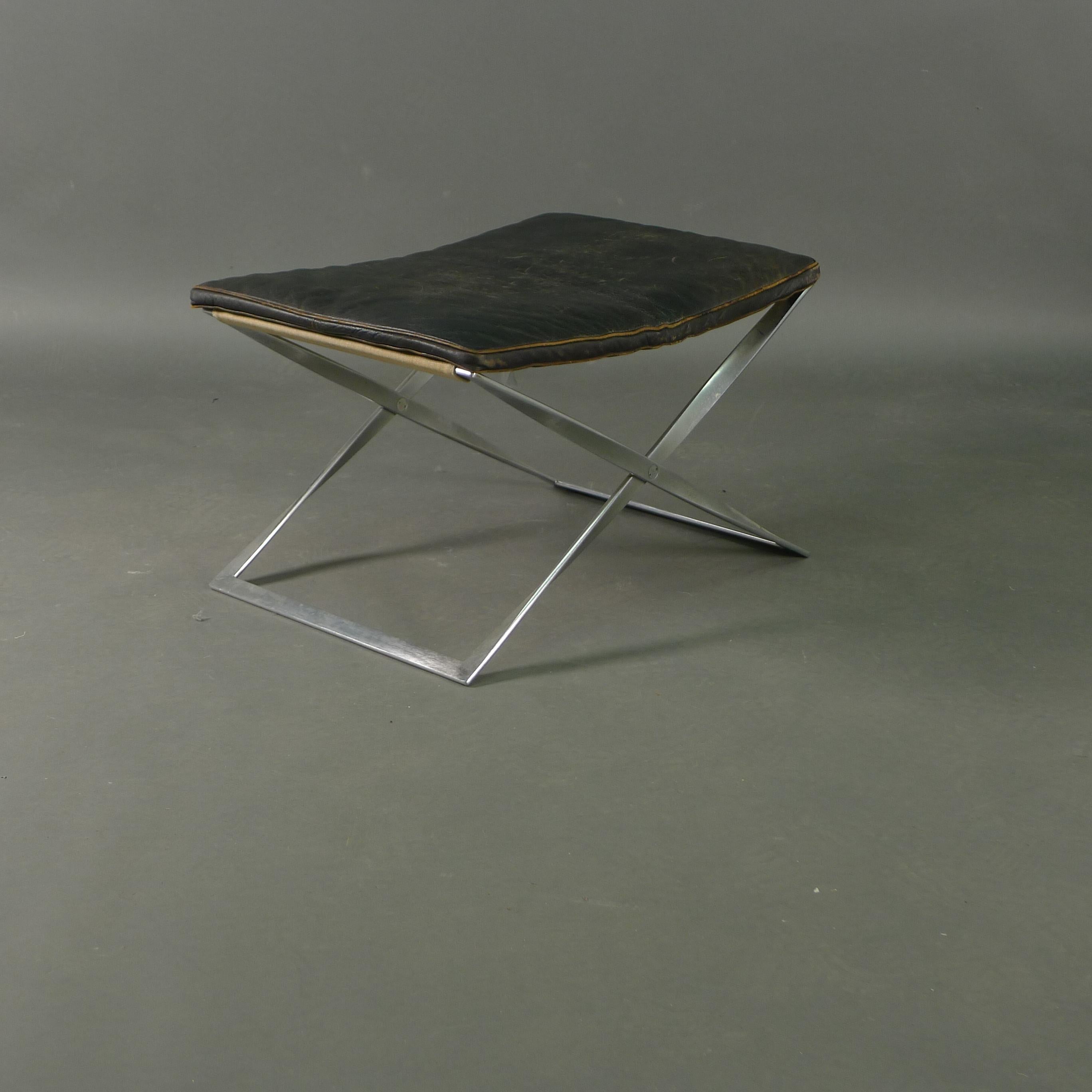 An early PK-91 folding stool in chromed steel with original slung canvas seat and additional loose cushion upholstered in brown leather.  By repute, the cushion is the work of Ivan Schlechter, a leatherworker who upholstered many of Kjaerholm's