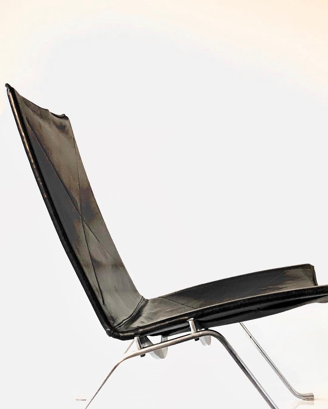 This iconic PK22 lounge chair in black leather was designed by Poul Kjaerholm, and executed by Fritz Hansen. The upholstery has signs of use according to its age.