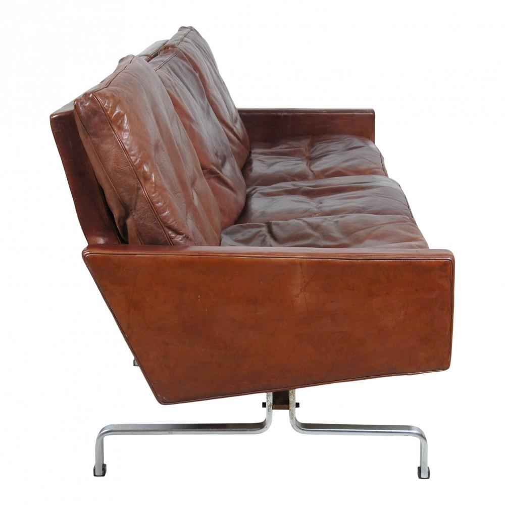 Poul Kjærholm PK 31/3 sofa in brown patinated leather from around the 70s, where the canvas under two cushions has some loose stitches, and there is a small crack in the middle and light rust on the frame. Otherwise in fine patinated condition
