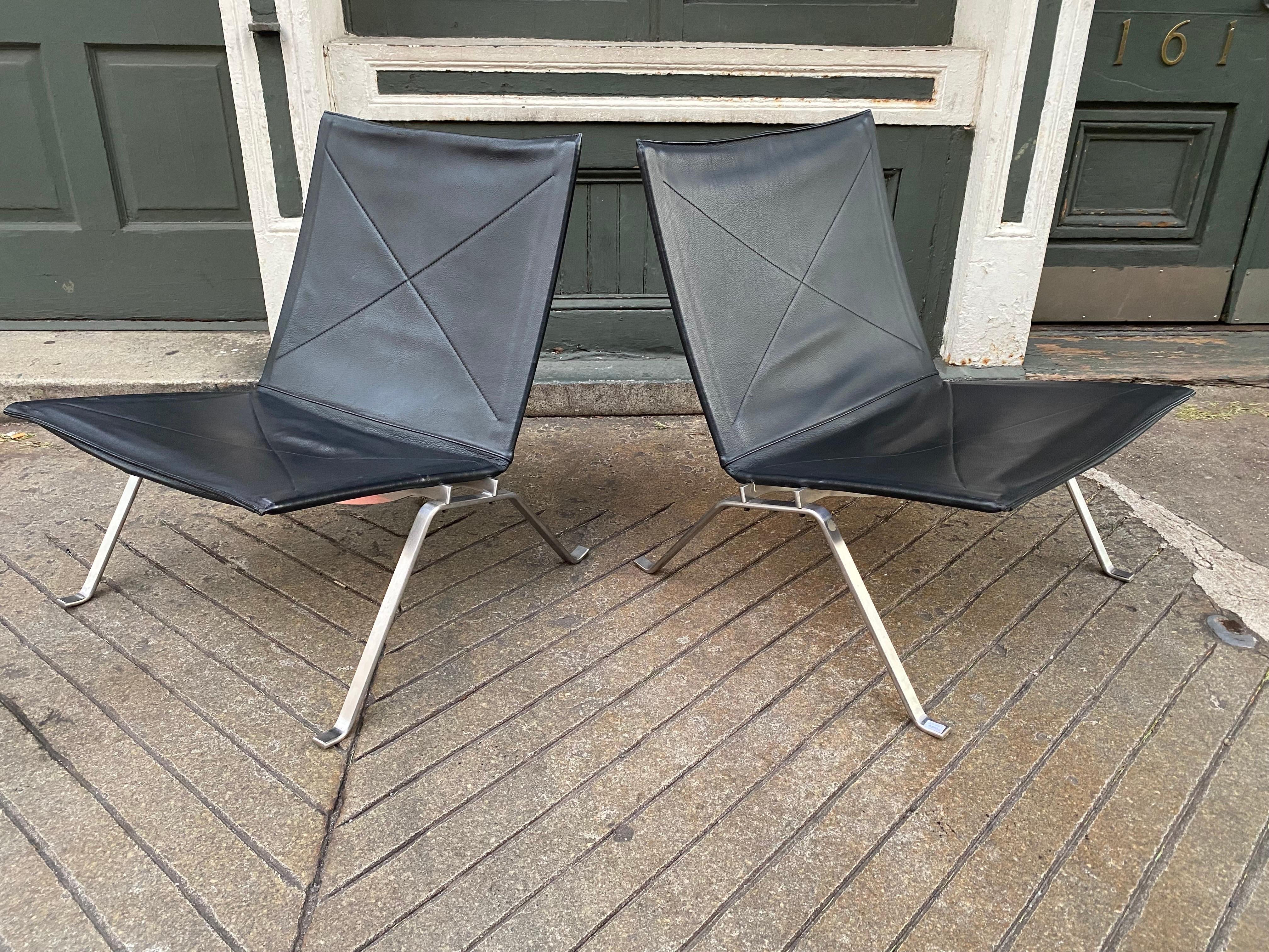 Pair of Poul Kjaerholm PK22 black leather sling chairs that were produced in 2000, they were sold through Fritz Hansen and Knoll. Overall very clean! Leather shows a couple wear marks and stainless steel very clean! Labels and stamps to underside.