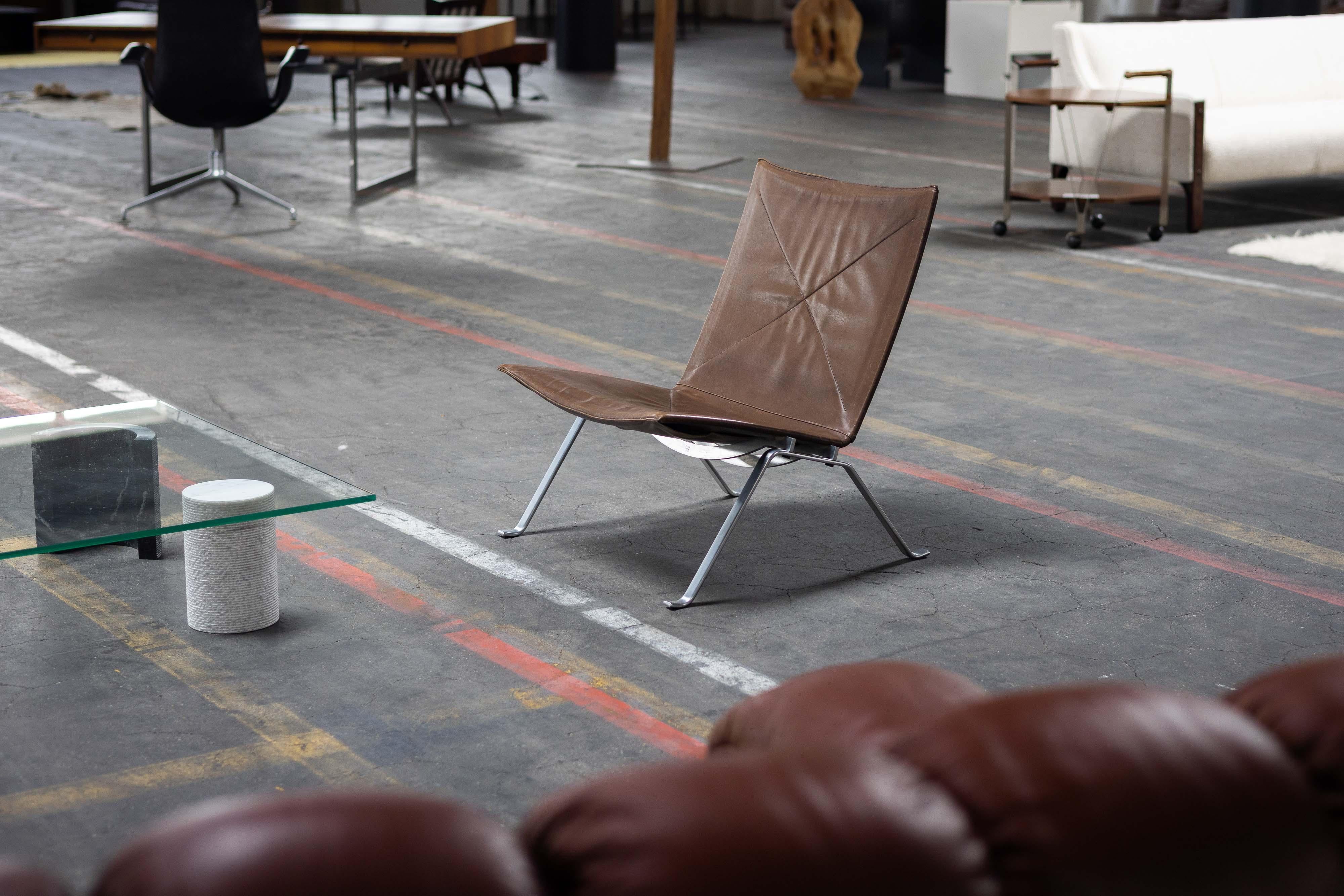 This original PK22 lounge chair, designed by the celebrated architect Poul Kjaerholm and manufactured by Ejvind Kold Christensen in Denmark in 1956, is a rare and iconic masterpiece of mid-century modern design. As one of the most celebrated lounge