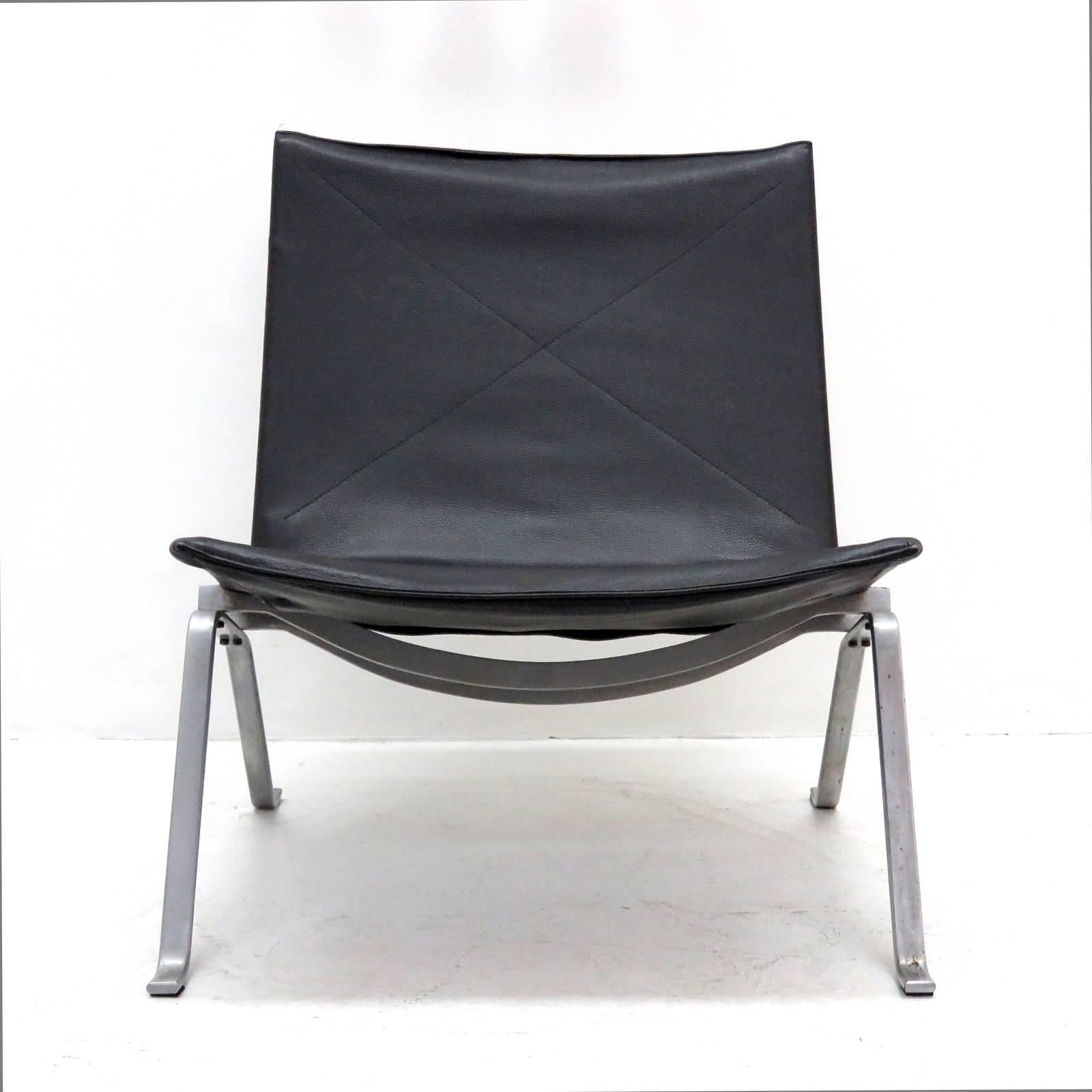 Iconic pair of PK 22 chairs by Poul Kjaerholm for E. Kold Christensen, Denmark in black leather on satin chromium-plated steel frame, signed.