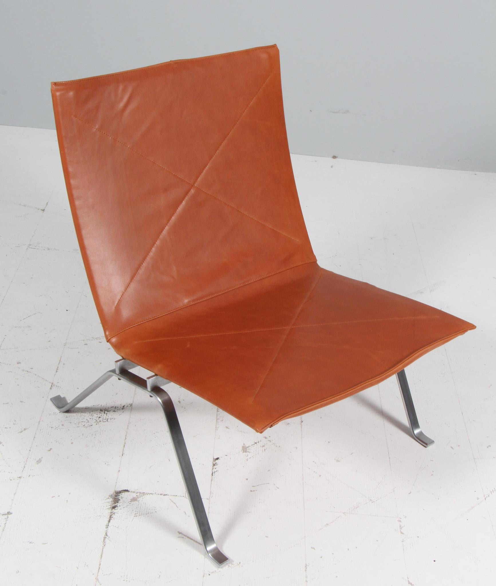 Poul Kjærholm lounge chair new upholstered with cognac full grain aniline leather. 

Frame of brushed steel.

Model PK22, made by Fritz Hansen.