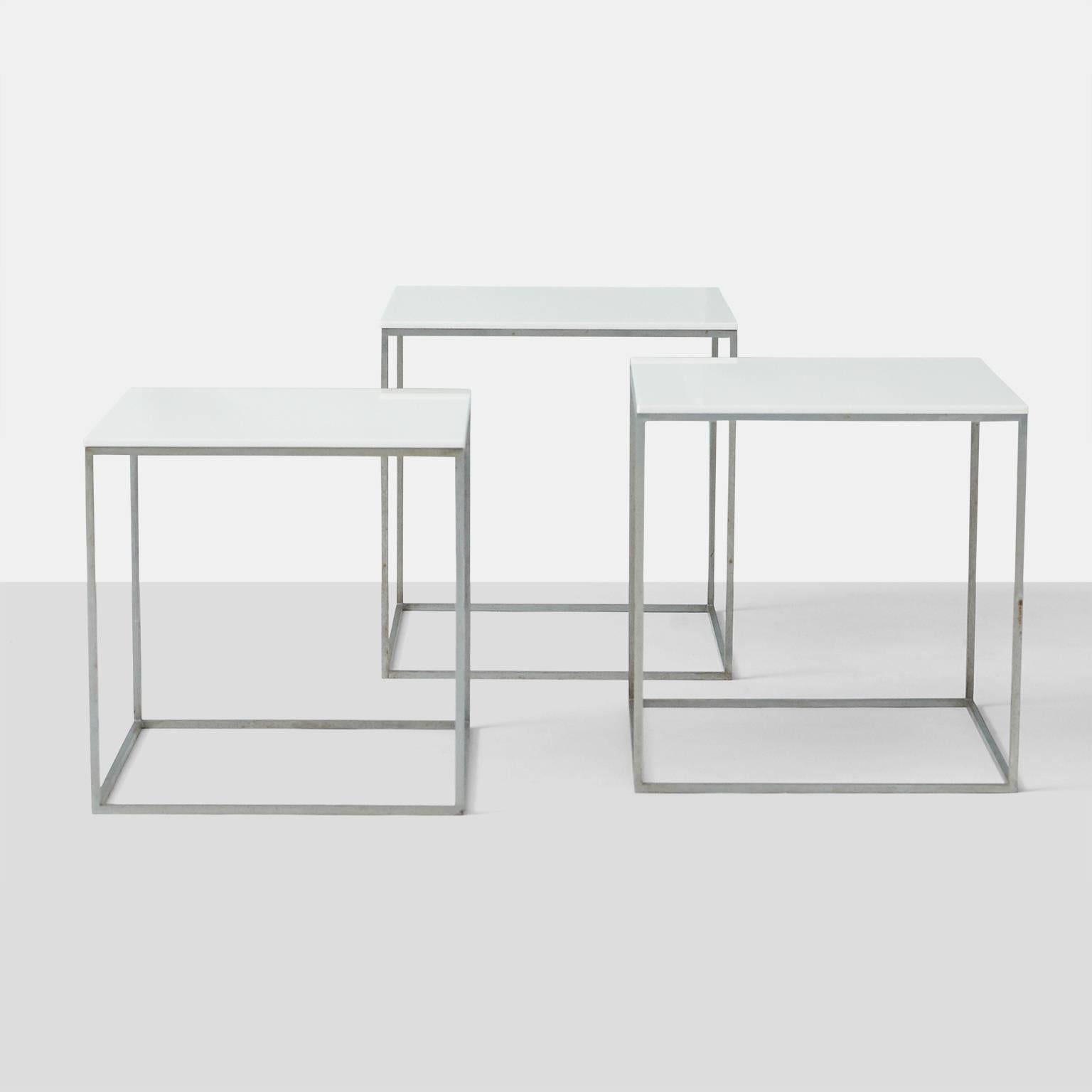 A set of three PK71 nesting tables by Poul Kjærholm for Ejvind Kold Christensen. The frames are chrome plated steel with polished white acrylic top.