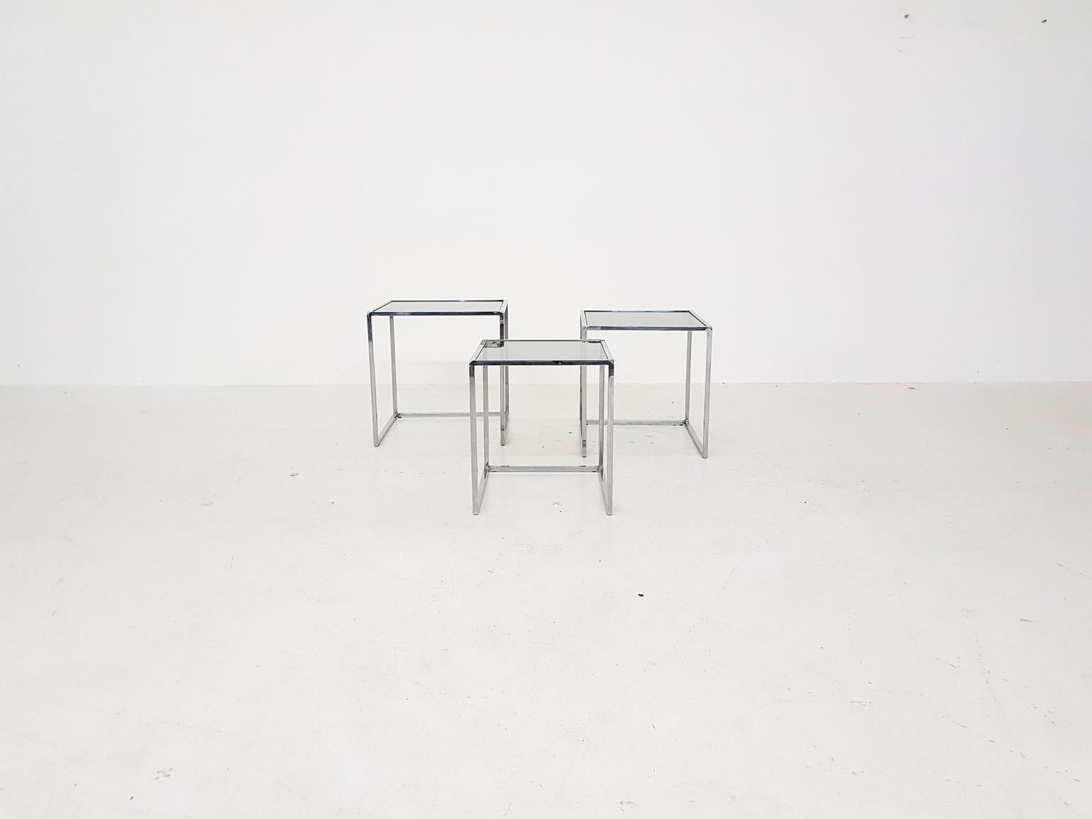 A nice set of three nesting tables made of chromed metal with a smoked glass top. The tables have some resemblances with the PK71 mimiset by Poul Kjaerholm for E. Kold Christensen or Fritz Hansen.

We think it is Dutch made in the 1970s. Tables