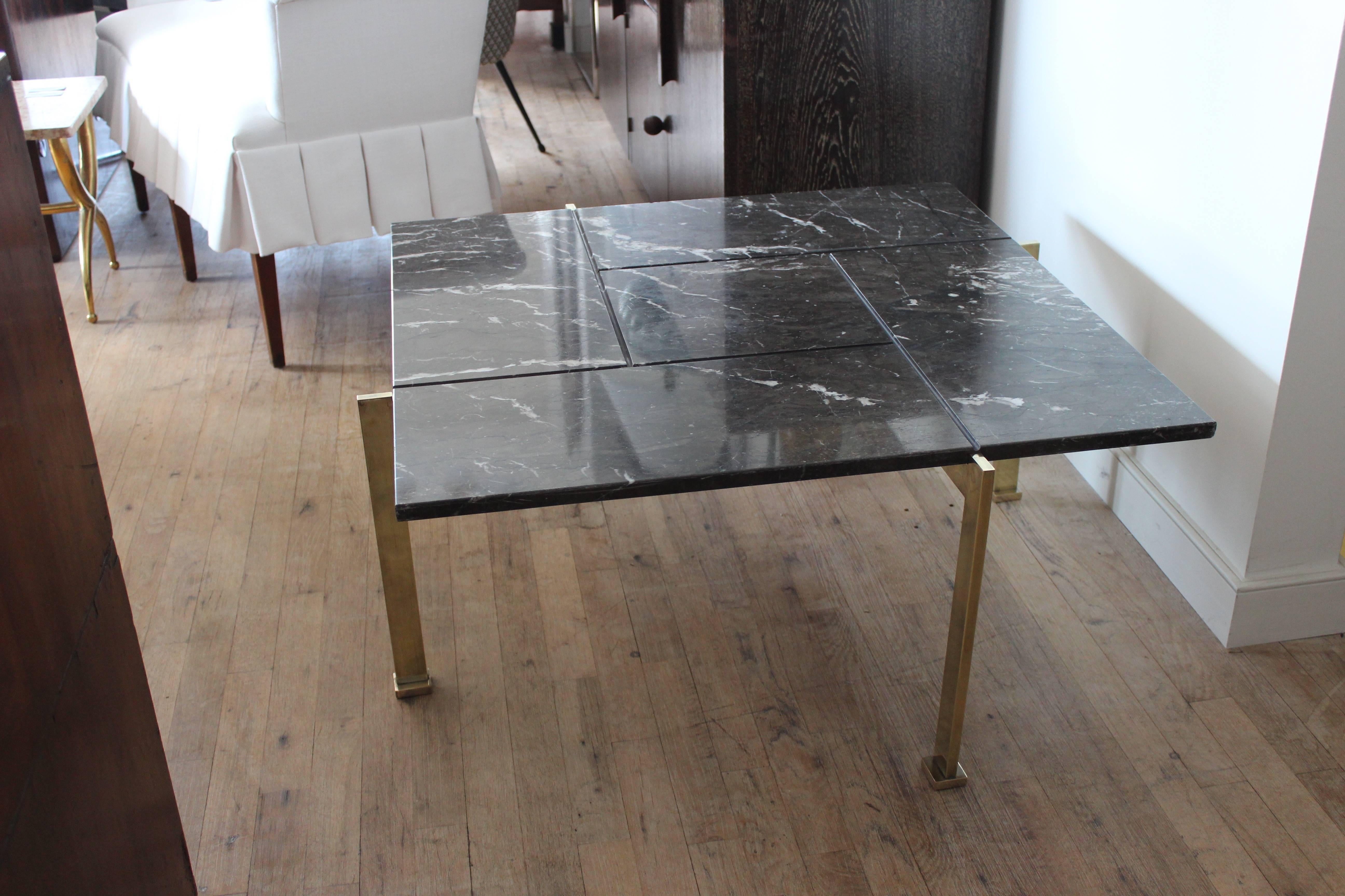 Beautiful scored marble-top table. Offset legs and brass tube base. In the style of Poul Kjaerholm.