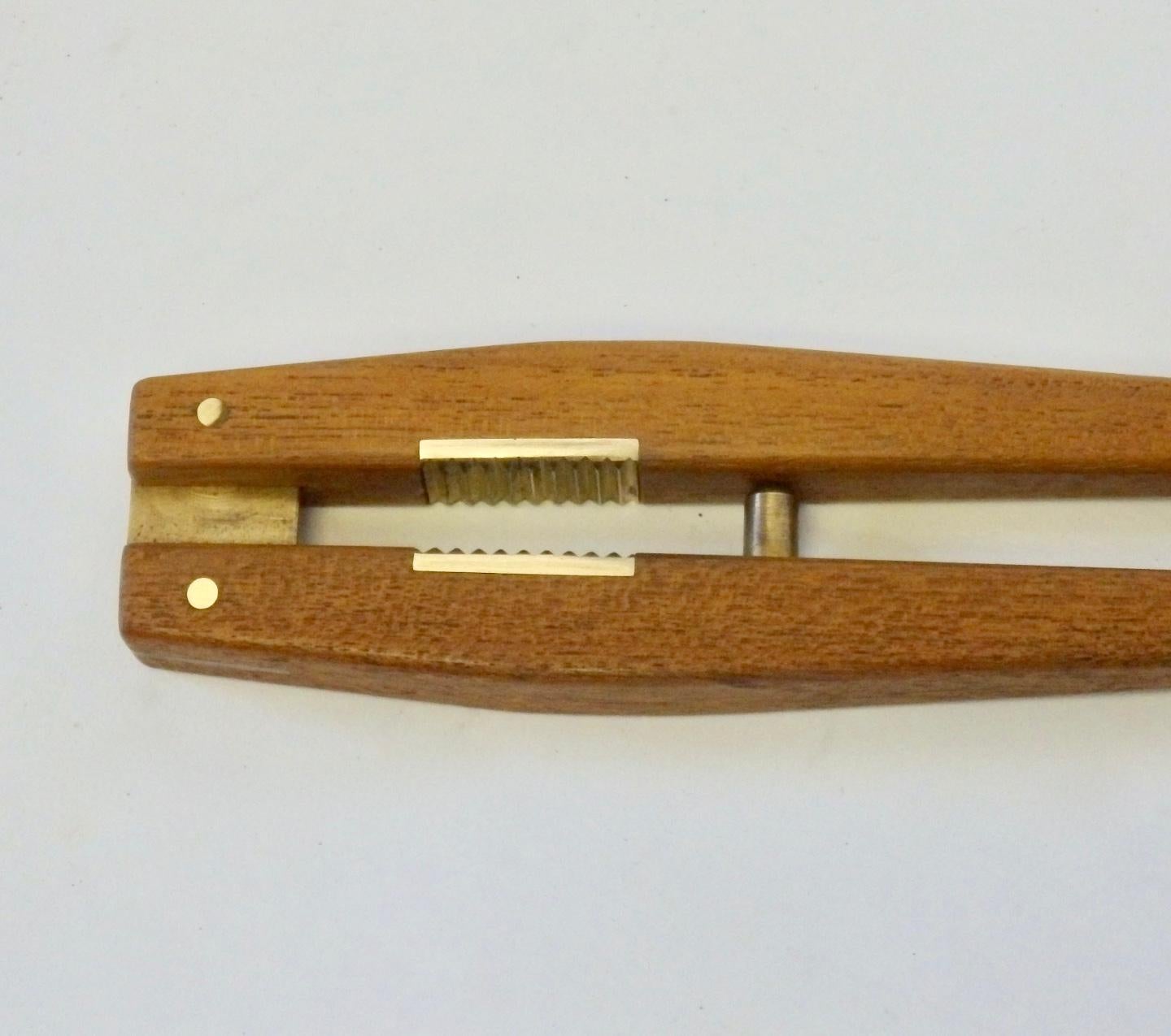 Beautifully made and detailed teak wood nut cracker with brass fittings.