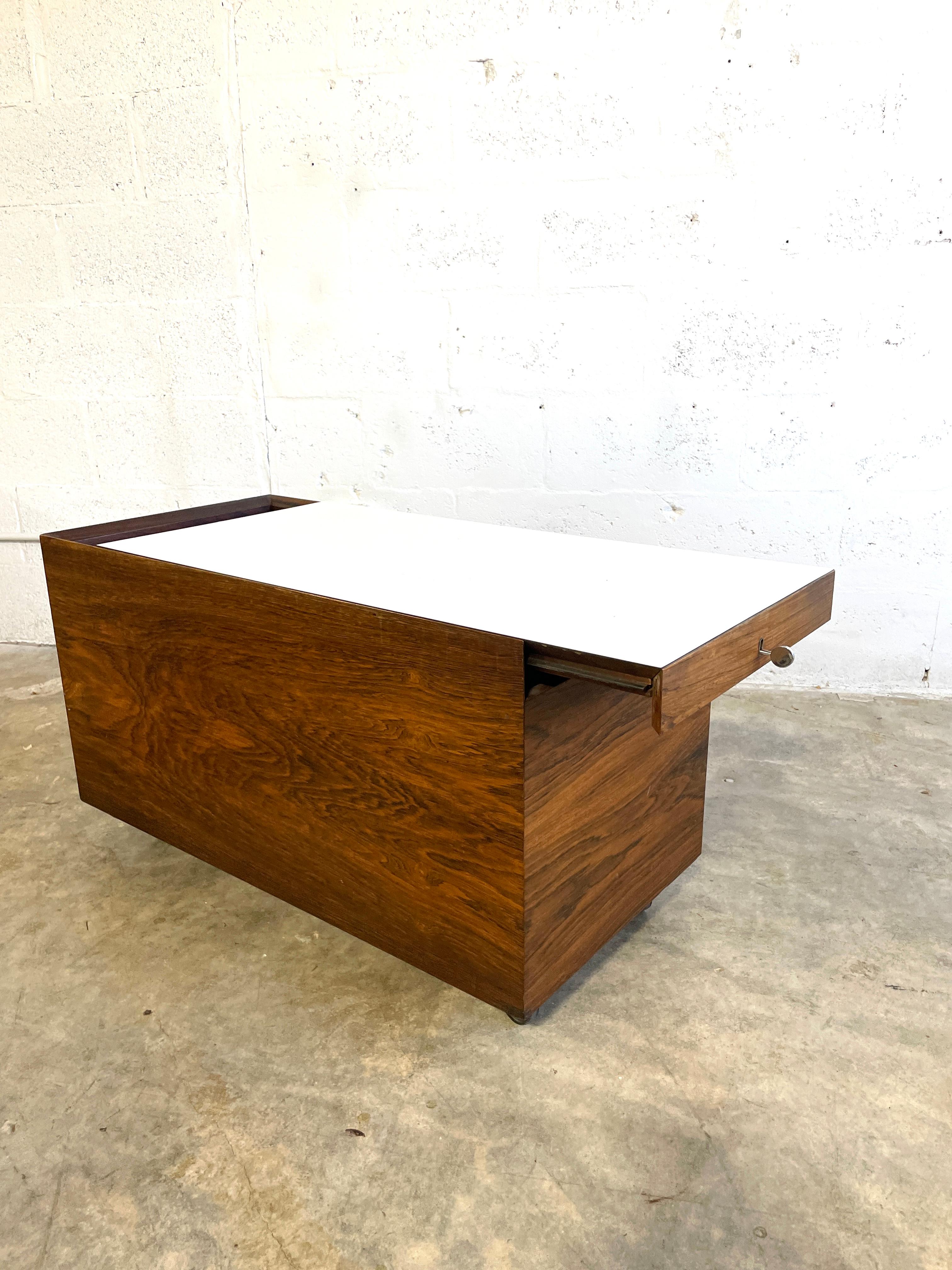 Rare dry bar table on wheels designed by Poul Norreklit and manufactured by Dyrlund, Denmark 1960. Top slides and reveals storage inside. 33wide 16.5d 19h