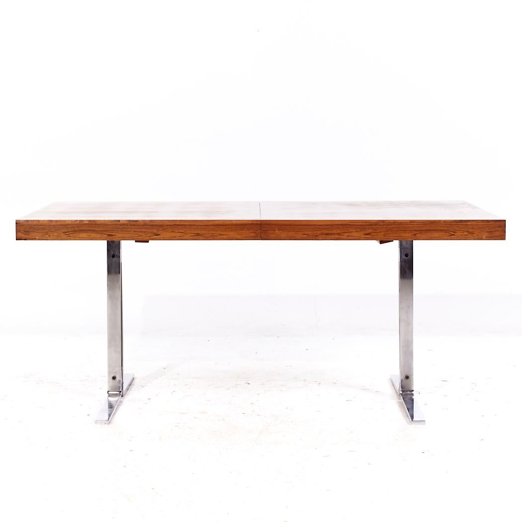 Poul Norreklit for Georg Petersens Mid Century Danish Rosewood and Chrome Hidden Leaf Expanding Dining Table

This table measures: 63 wide x 36.5 deep x 27.5 high, with a chair clearance of 24.75 inches, the hidden leaf measures 23.5 inches, making