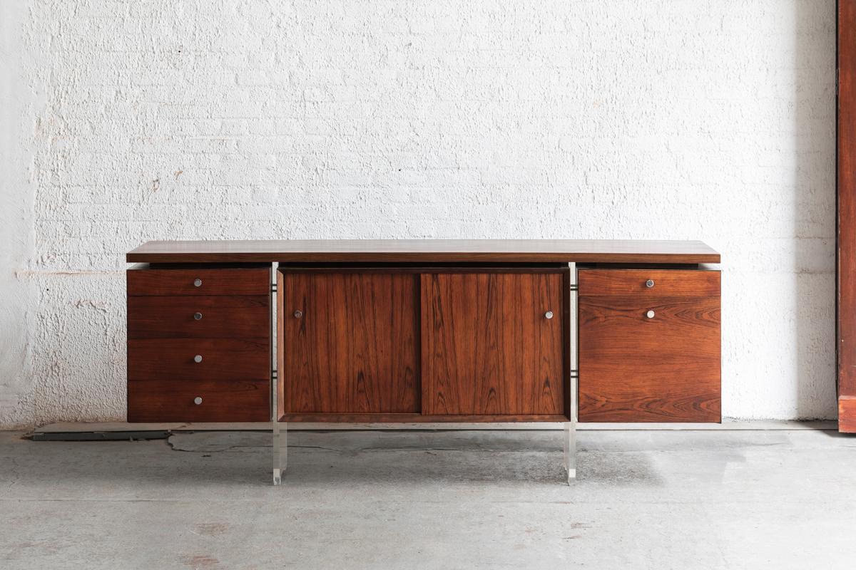Rare sideboard designed by Poul Norreklit and produced by Georg Petersens in Denmark in the 1960’s. This piece, made of solid rosewood and rosewood veneer feels heavy but looks to be floating thanks to the lucite legs. This exceptional sideboard is