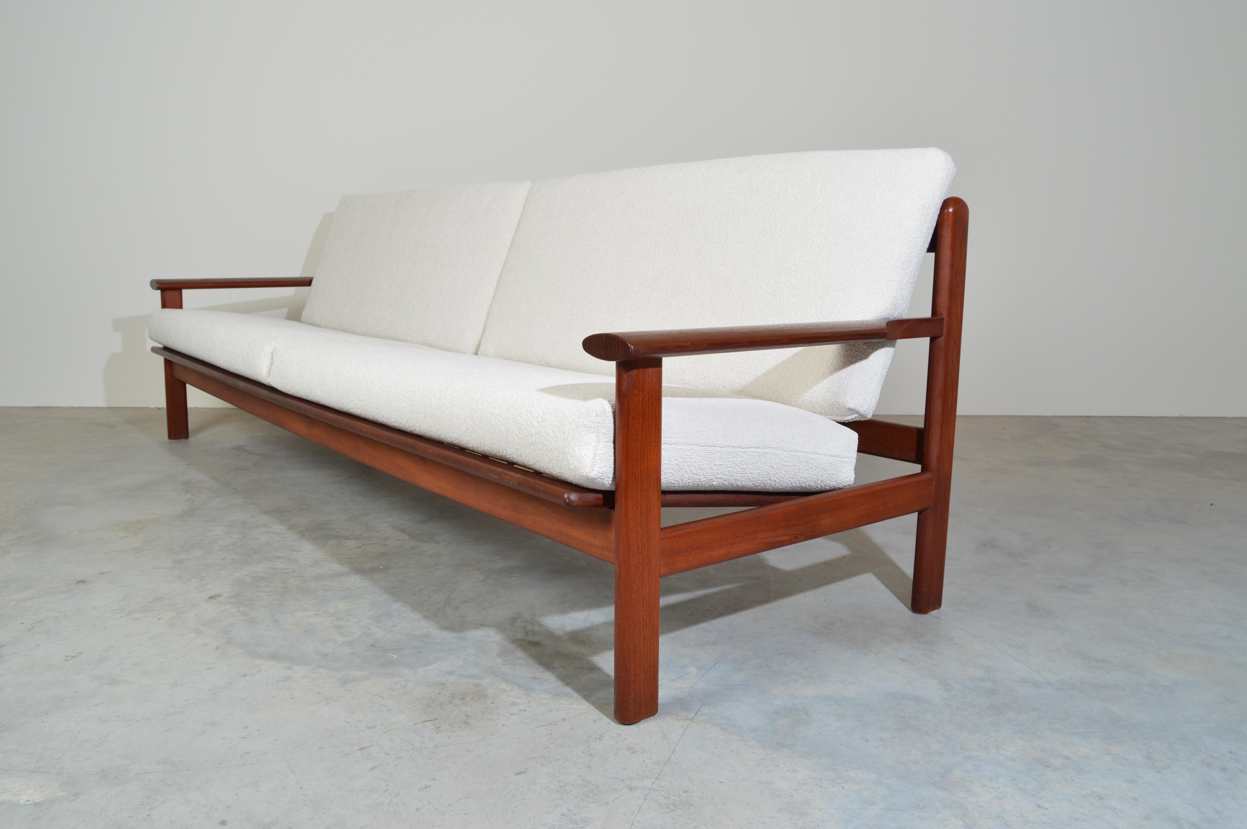 A beautifully crafted and solid sofa frames in sculptural teak having fresh Italian Boucle’ upholstery with firm and very comfortable new cushioning suspended by a series of rubber straps that are in fantastic condition. 
Overall condition is