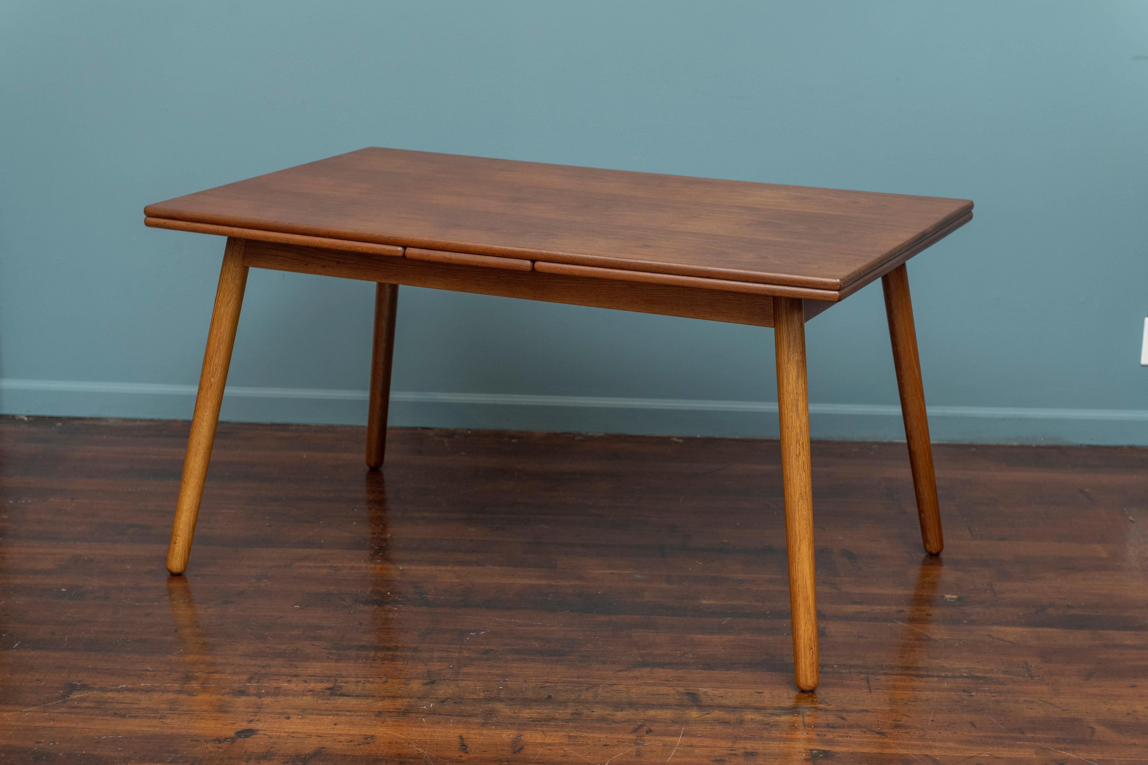Poul Volther design extension dining table for FDB Mobler, Denmark. High quality construction and materials in this extending teak and oak dining table. Newly refinished with a grain matched teak top and leaves on an interesting angled and rounded