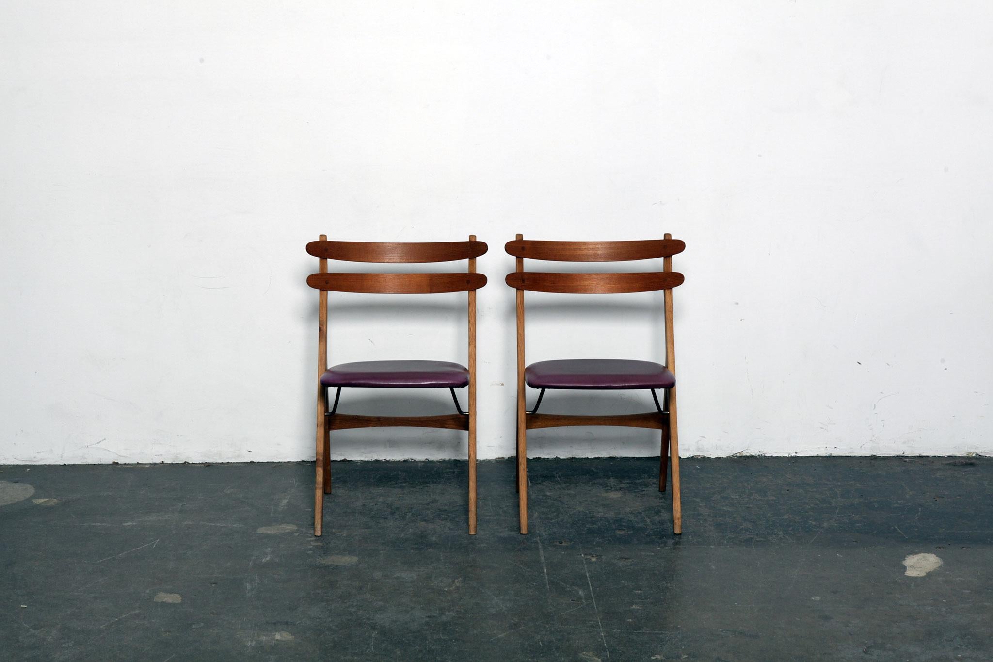 Pair of Danish 1950s side chairs with bent teak backs, oak 'A' frames with brass supports, newly upholstered in a plum colored leather and newly refinished. Designed by Poul Volther.