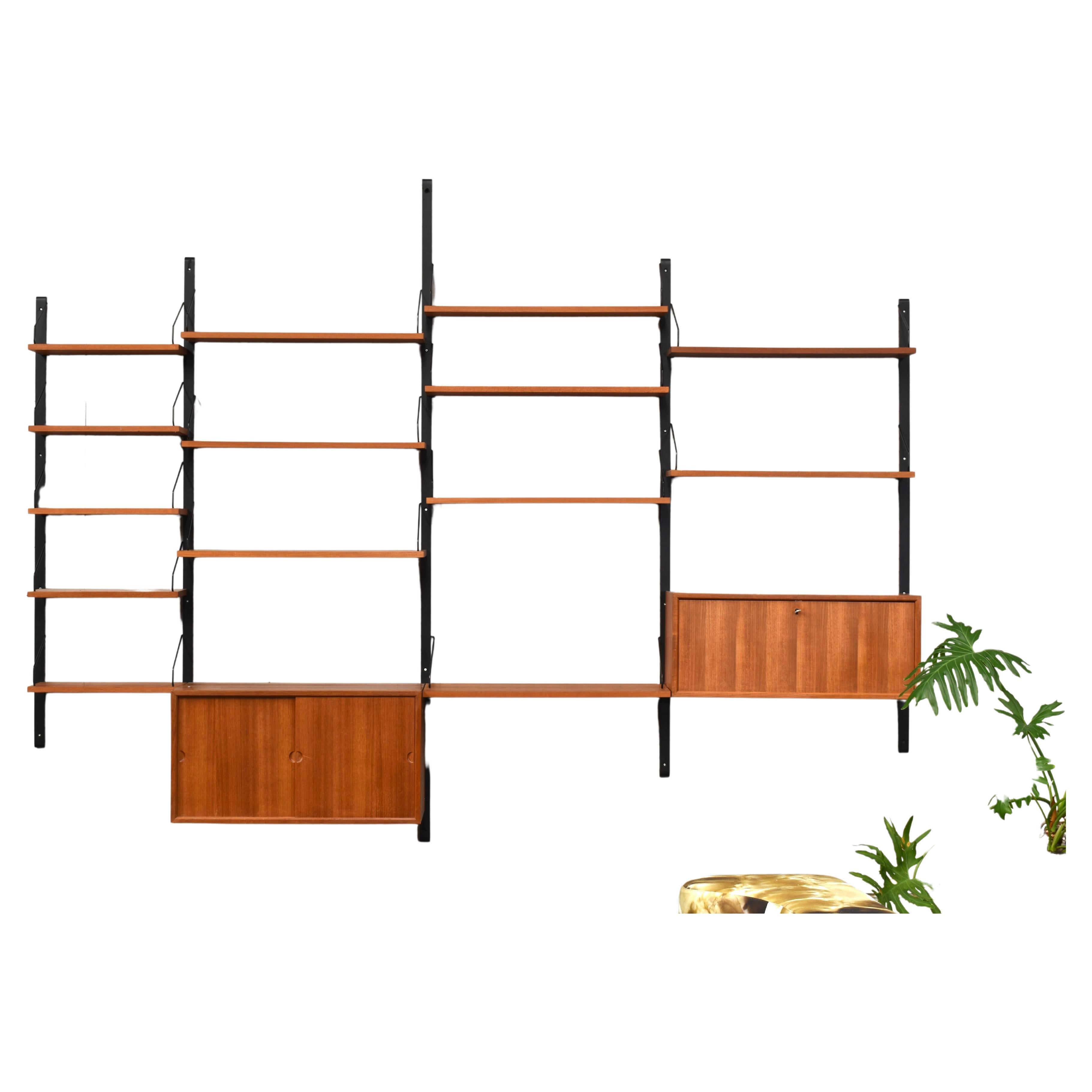 Teak modular wall unit by Pool Cadovius for CADO, Denmark - circa 1950-60. The wall unit still remains in very good condition after all these years with some minor signs of age and use. It features 2 cabinets, 8 normal width shelves, 5 rare to find