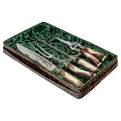 Juego de trinchar aves, metal plateado y mango de madera tallada.