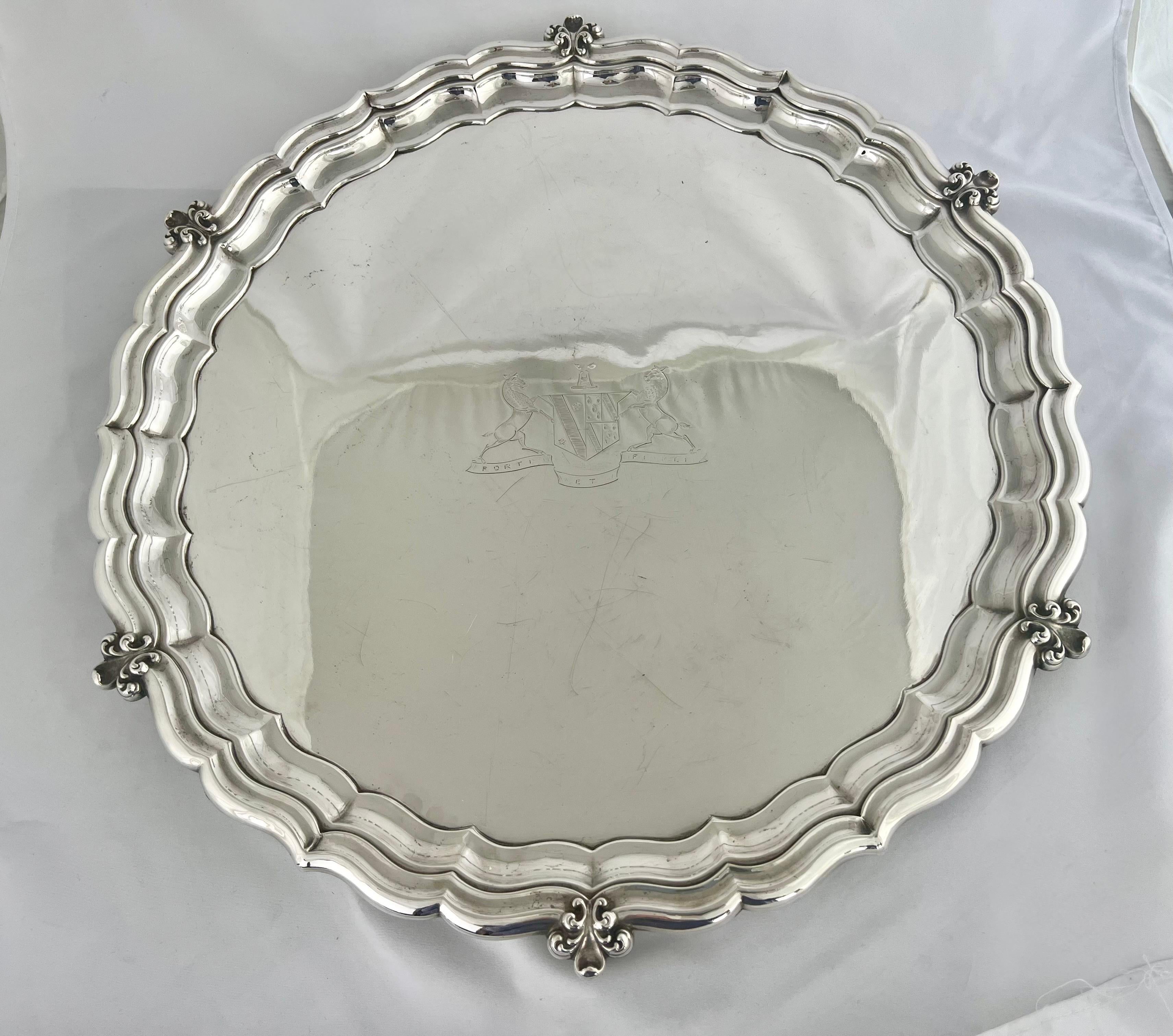 Early 20th century silver plate round tray with etched coat of arms depicting a pair of lions holding a sheld. The tray stands on five fleur dys lis feet. it is stamped 