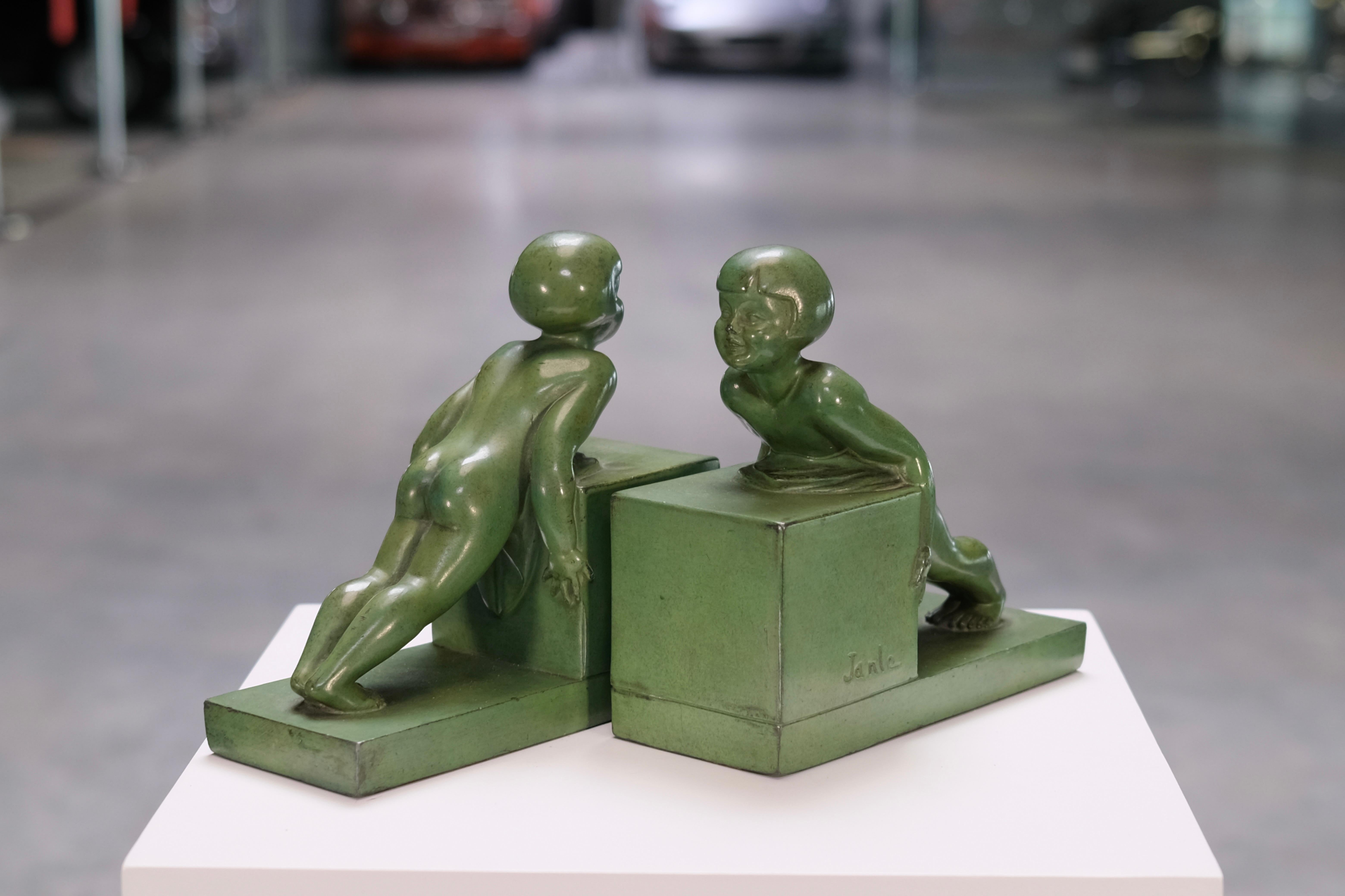 A rare treasure from the height of the French Art Deco era: This original pair of sculptural bookends, titled “POUSSÉE”, captures the joyful play of two children in motion. Designed by Janle and cast by the legendary Max Le Verrier foundry, these