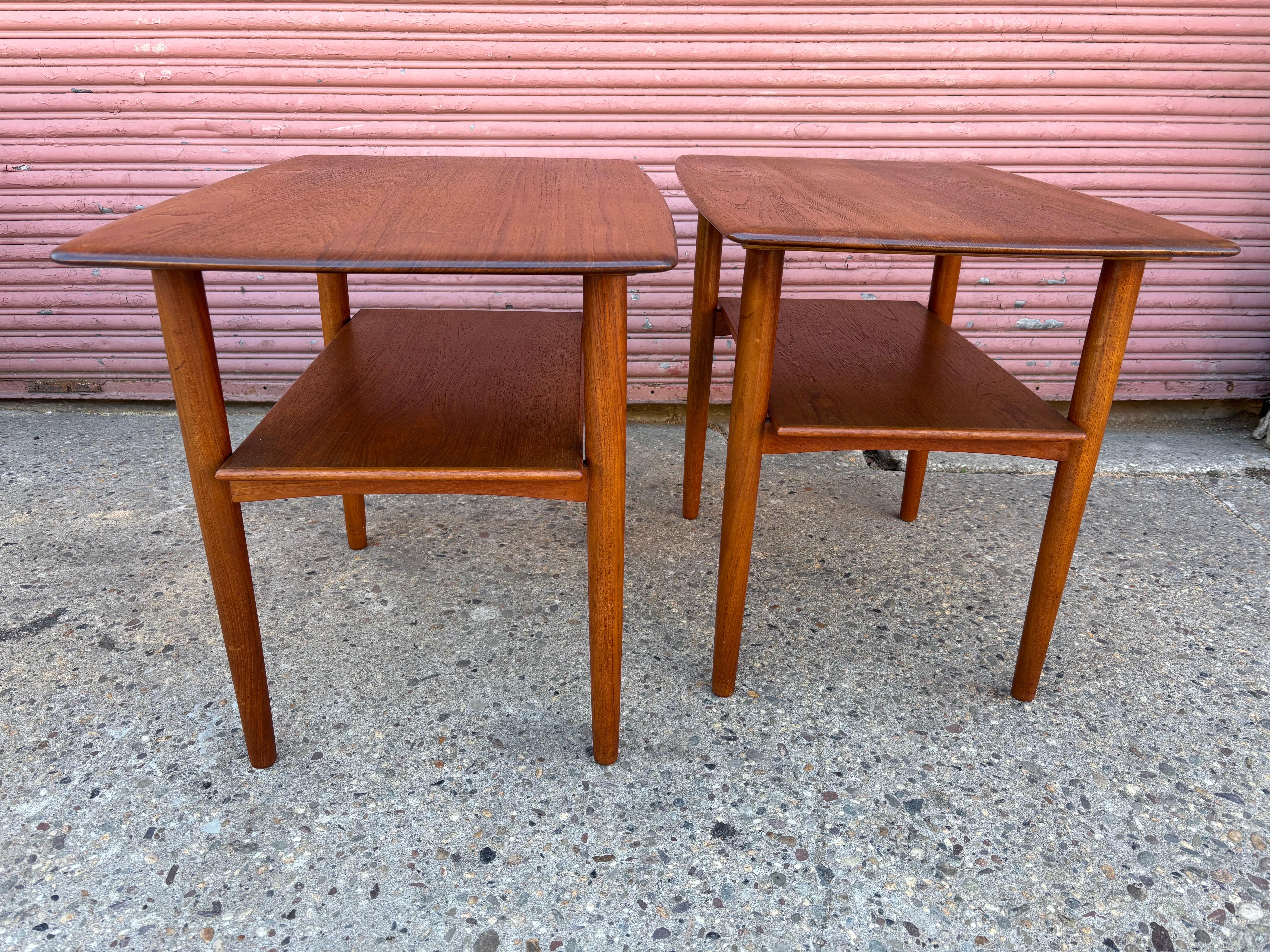 Pair of Solid Teak End Tables made by Povl Dinesen Cabinetmakers.  Refinished tops and everything cleaned and oiled.  Bottom shelf is 14.5 high.  Tapered legs.  Stamped on bottom.