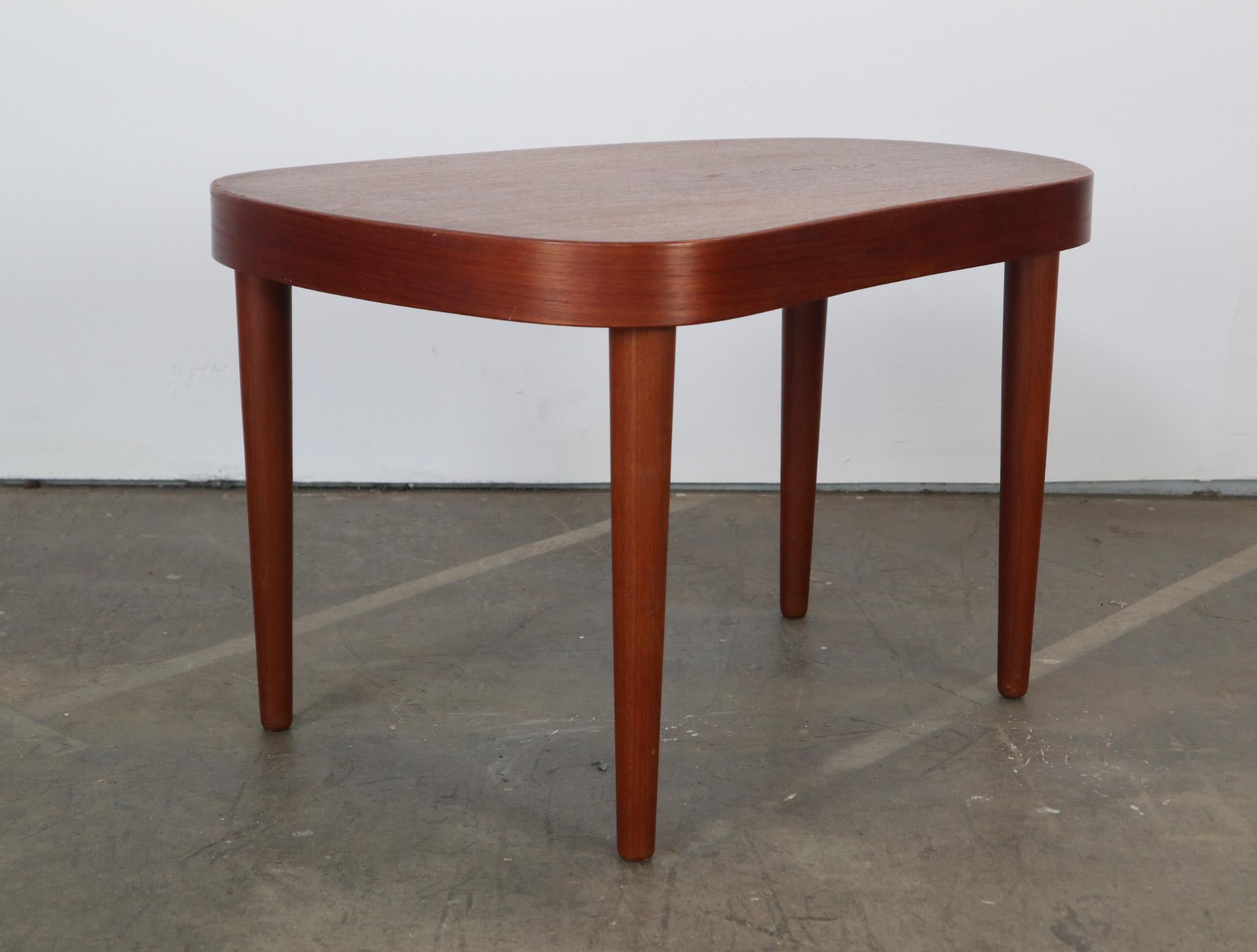 Lovely Danish biomorphic kidney shaped side table by Poul Dinesen. Gorgeous deep teak dolor and grain. Perfect beside a sofa or bed. Can accommodate a large lamp or planter.