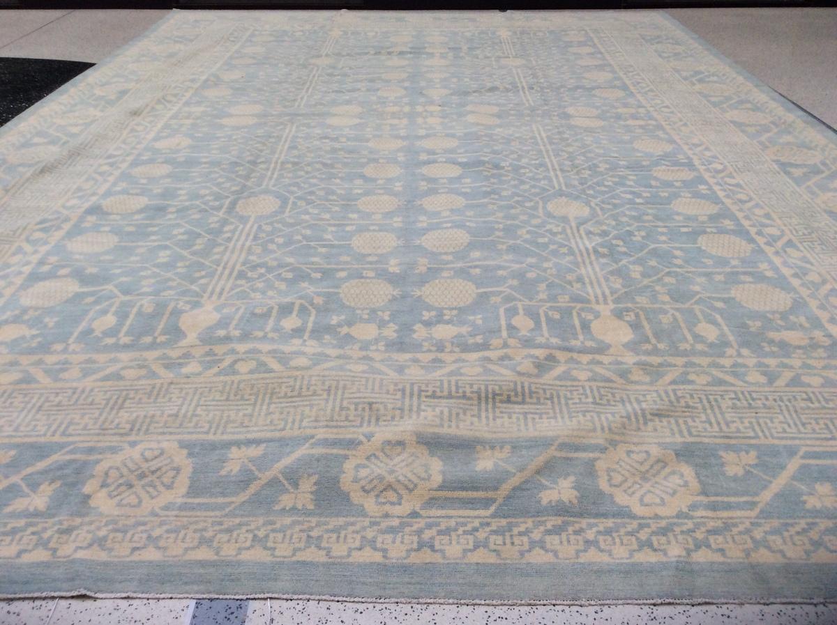 Dieser puderblaue und beigefarbene Khotan-Teppich mit Granatapfelmuster ist handgeknüpft und stammt aus Pakistan. Der jahrhundertealte Khotan-Stil hat seinen Ursprung im heutigen Westchina. Wie seine historischen Vorbilder kombiniert diese