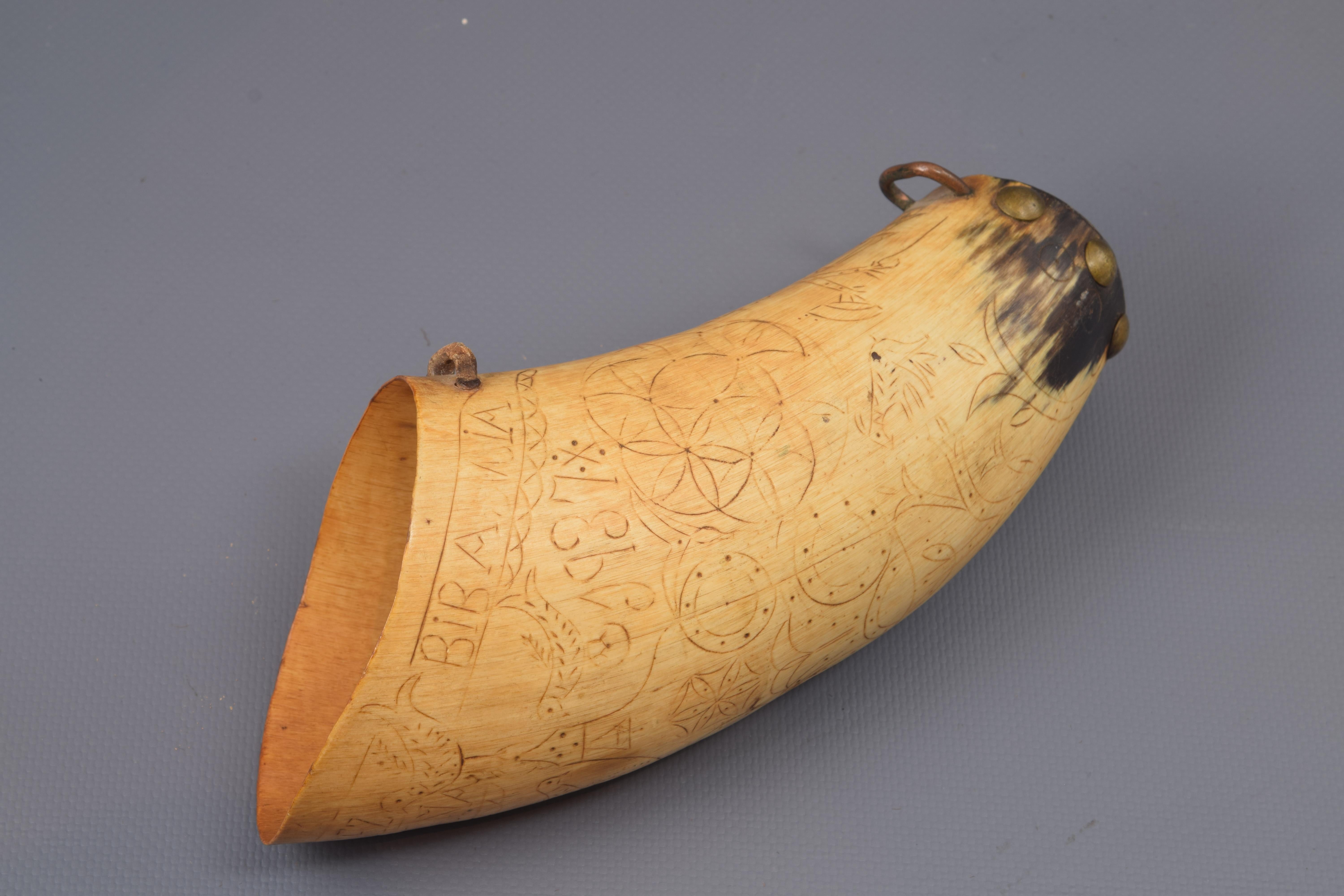 Dusting carved horn, metal. With registration and date. Spain, 1937.
Container to store gunpowder formed from an animal horn (very possibly cattle) to which the tip has been cut and covered this area (with metal tacks), and equipped with some