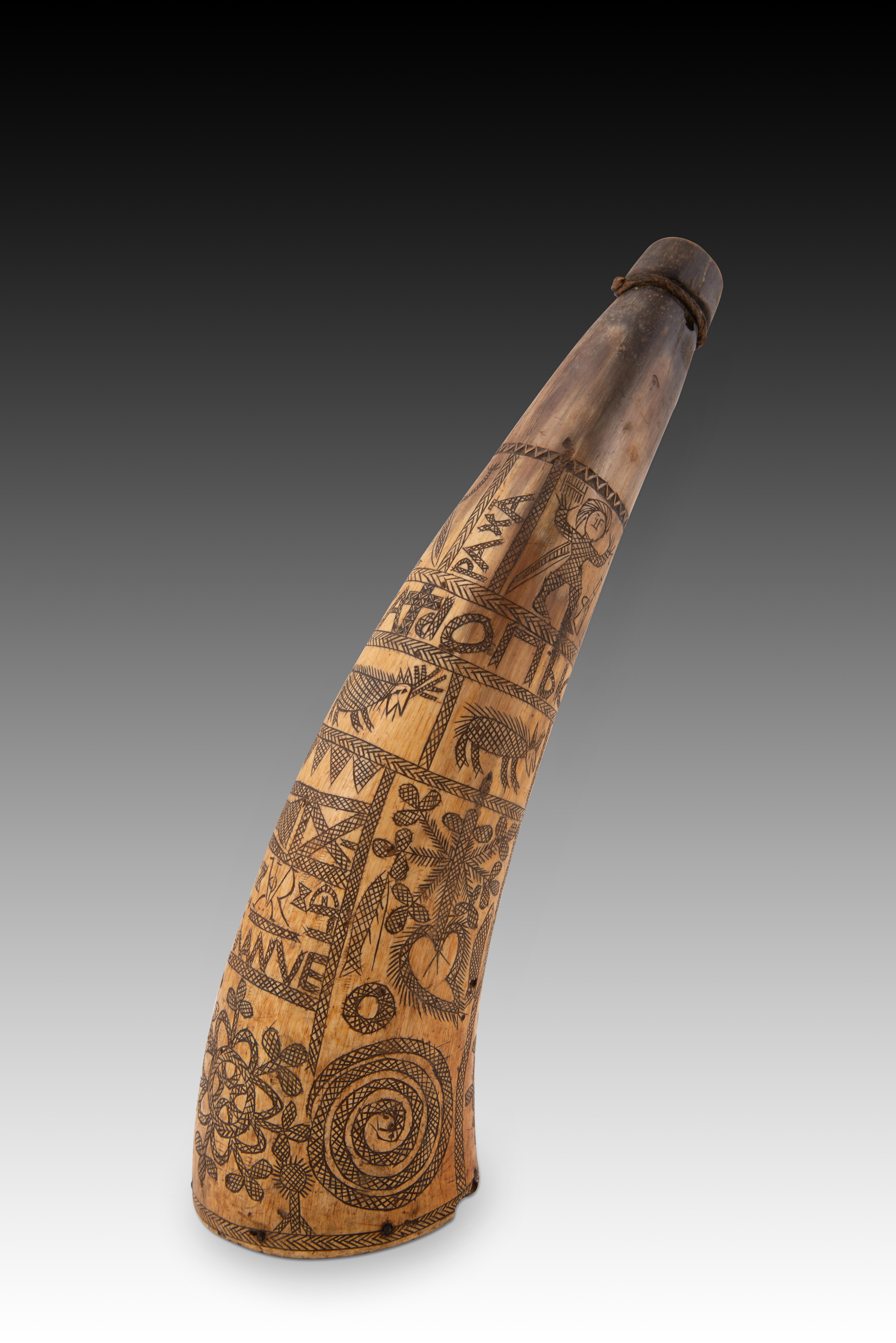  Powder keg. Engraved horn, rope, cork. Spain, 19th century.
A container for storing gunpowder made from a cow's horn and decorated on the outside with a series of figurative, geometric and vegetal engravings and inscriptions enhanced with dark or