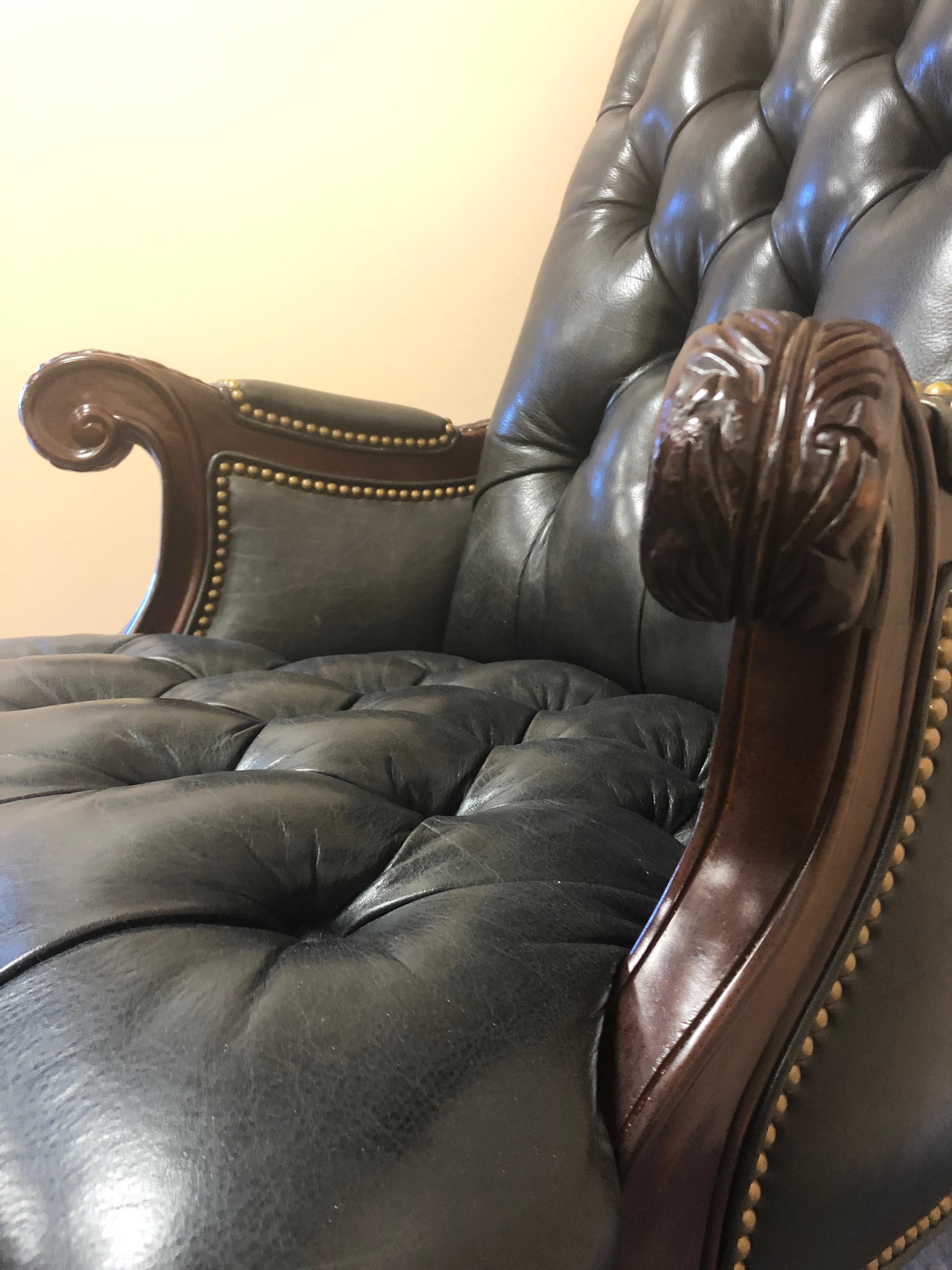 Very rich looking dark charcoal tufted leather executive chair having carved mahogany arms and swivel base on brass casters. Great looking from every angle.
Measures: Arm height 29
seat depth 21.
