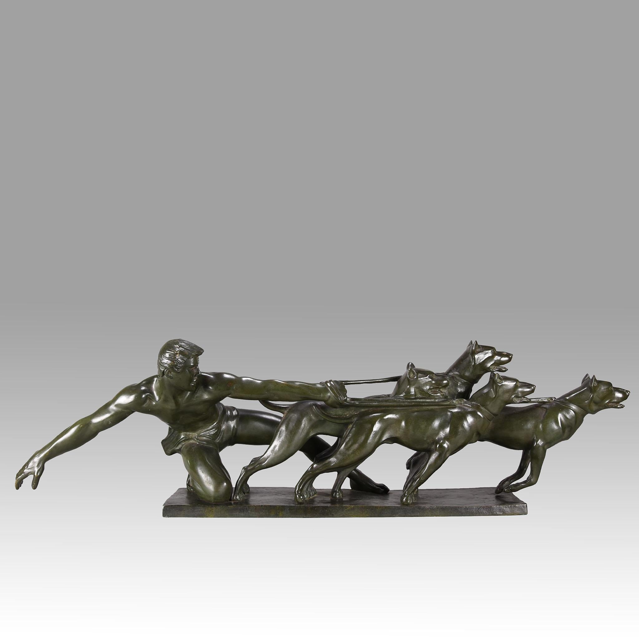 A tremendous early 20th century Art Deco bronze group of a strong athletic man holding the leashes of four powerful hounds as they strain to be released. The bronze exhibiting a rich green patinated surface with excellent hand finished surface