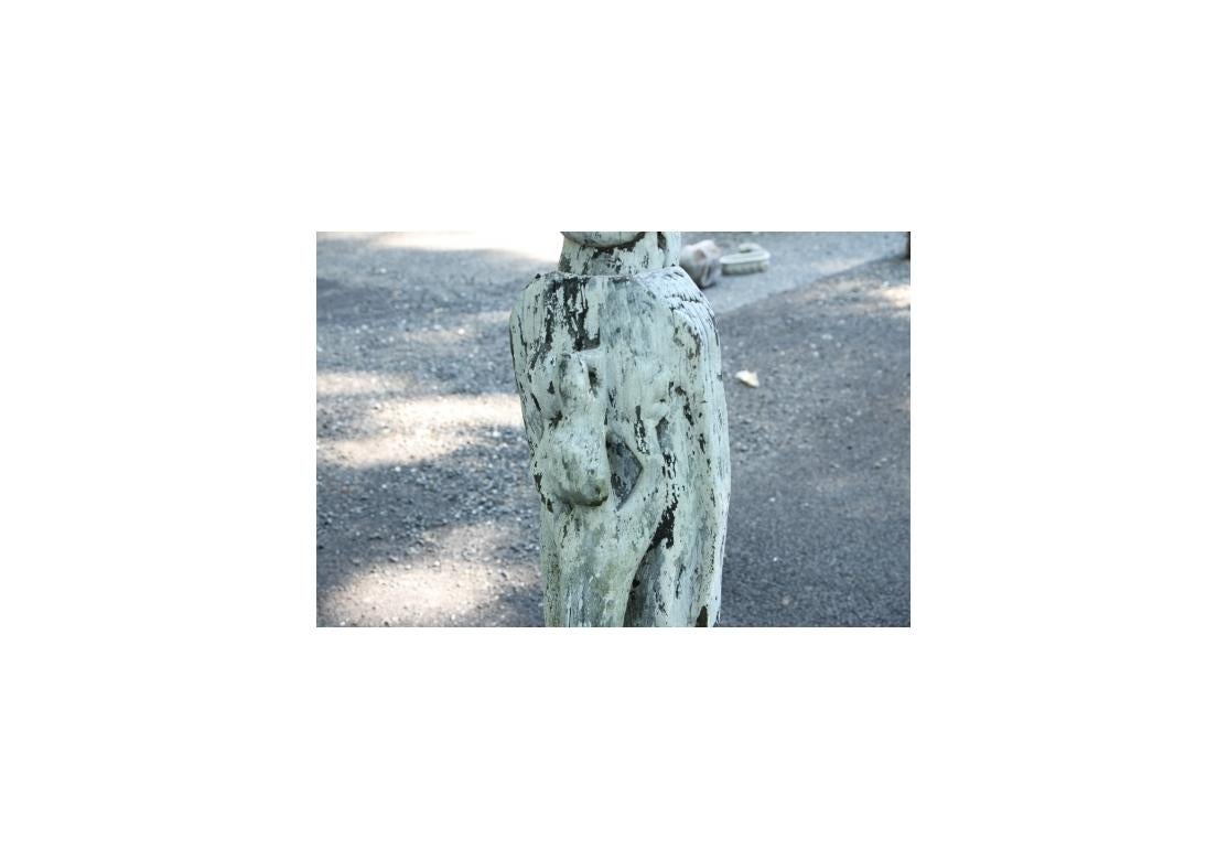 Powerful and haunting carved  figural sculpture  of a standing female figure in close embrace with an animal attendant, possibly a crocodile. The Sculpture is very worn and distressed with splintering, losses, paint losses and wear. The head removes