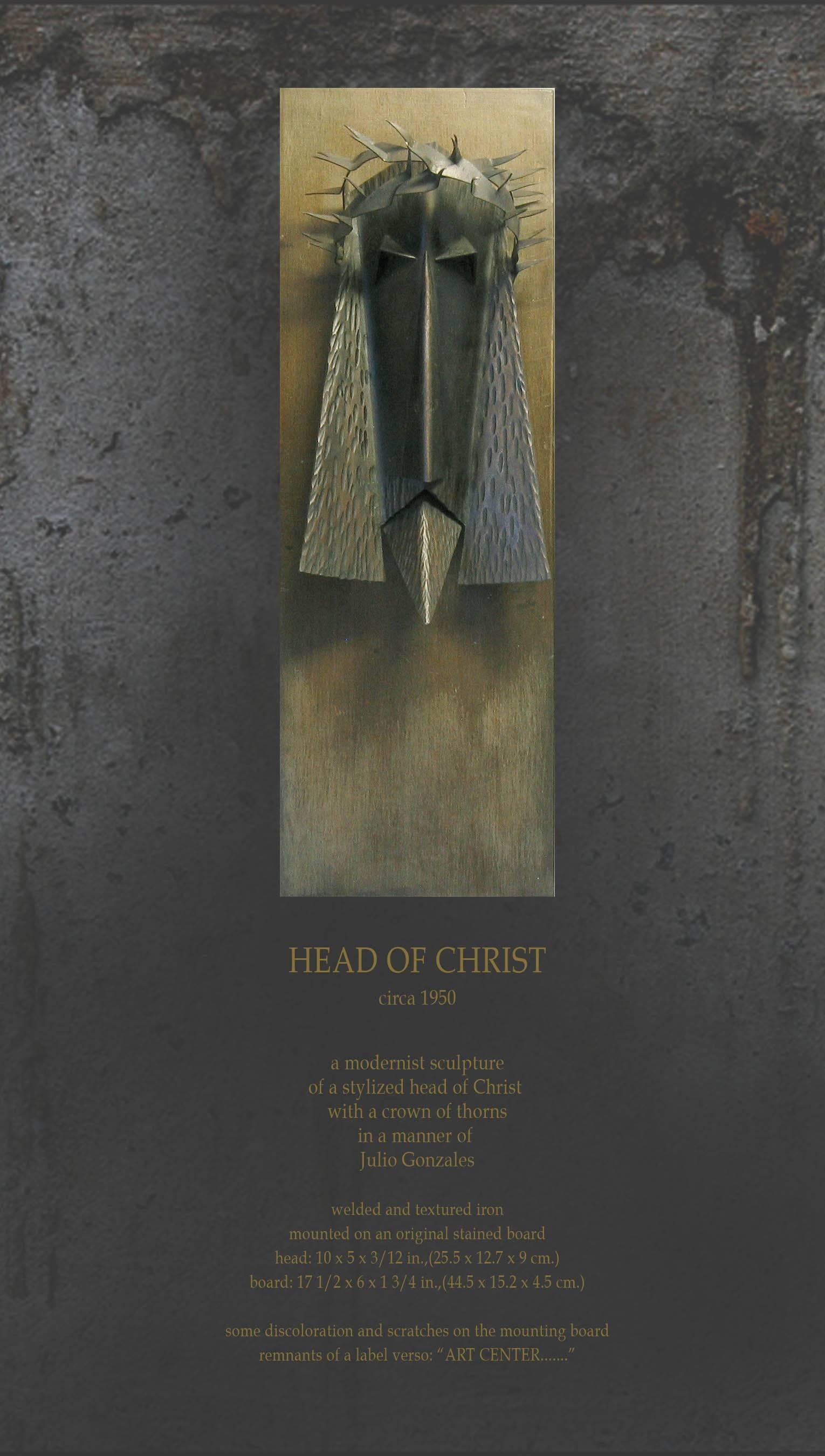 Une puissante tête de Jésus-Christ en fer soudé moderniste, vers 1950, une sculpture moderniste d'une tête stylisée du Christ avec une couronne d'épines à la manière de Julio Gonzales. En fer soudé et texturé monté sur un panneau teinté d'origine,