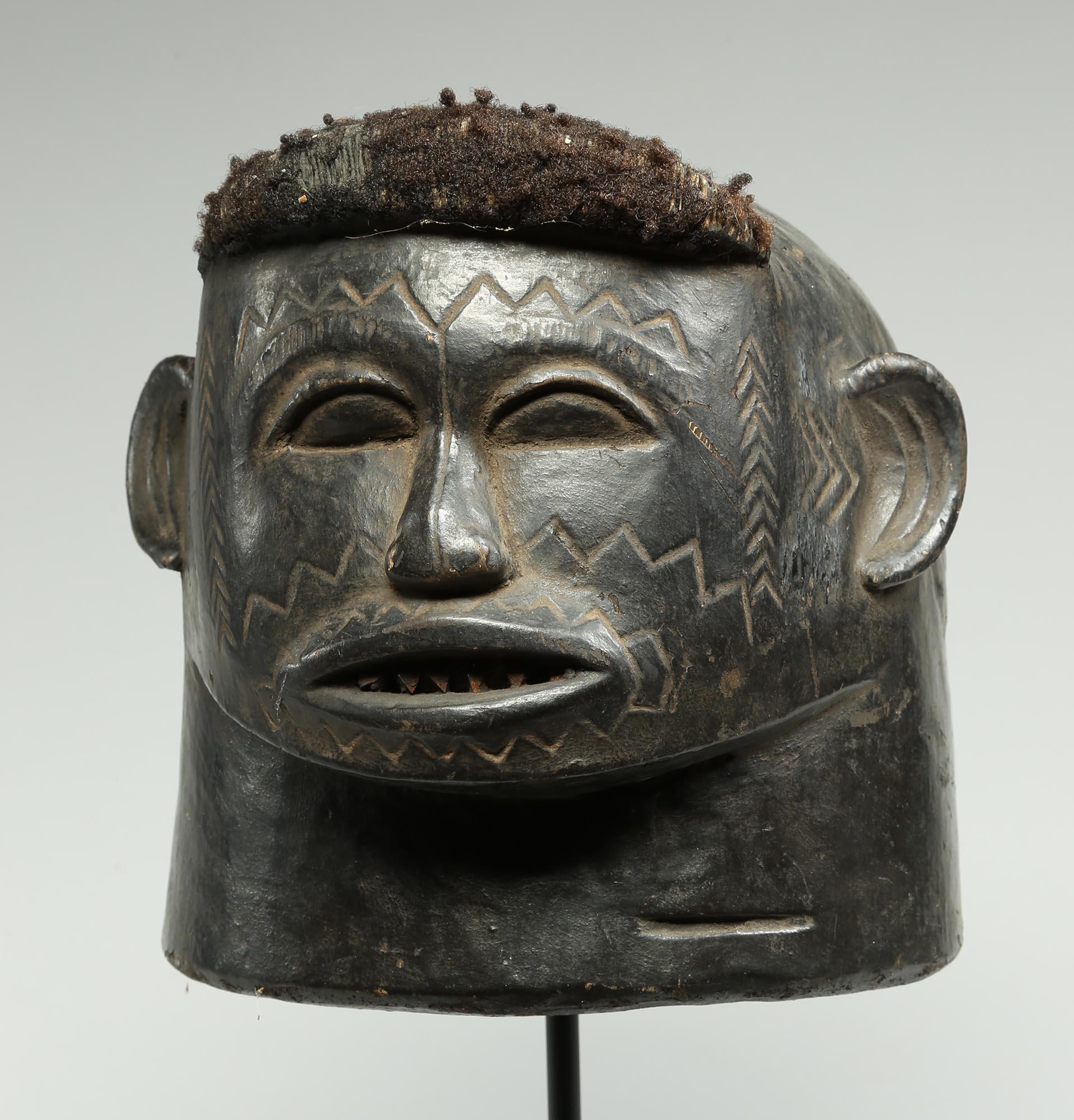 Powerful Scarified Makonde portrait helmet mask from Tanzania. Early 20th century with heavy dark patina from traditional tribal use, wear inside from being used. Finely carved features, incised scarification zig zag lines on cheeks, forehead and