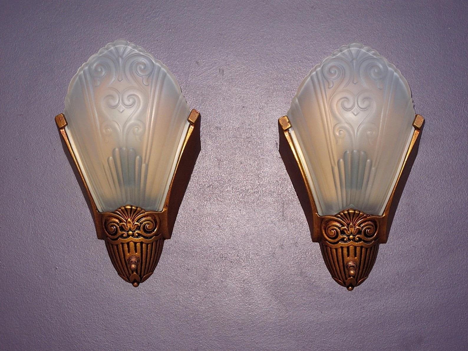 Priced per pair with possibly more than 1 pair available.
Simple and elegant vintage slip shade wall sconces by Virden of Milwaukee. Dates to late 1920s through the 30s, the Art Deco period of American design. Solid cast iron back with clear frosted