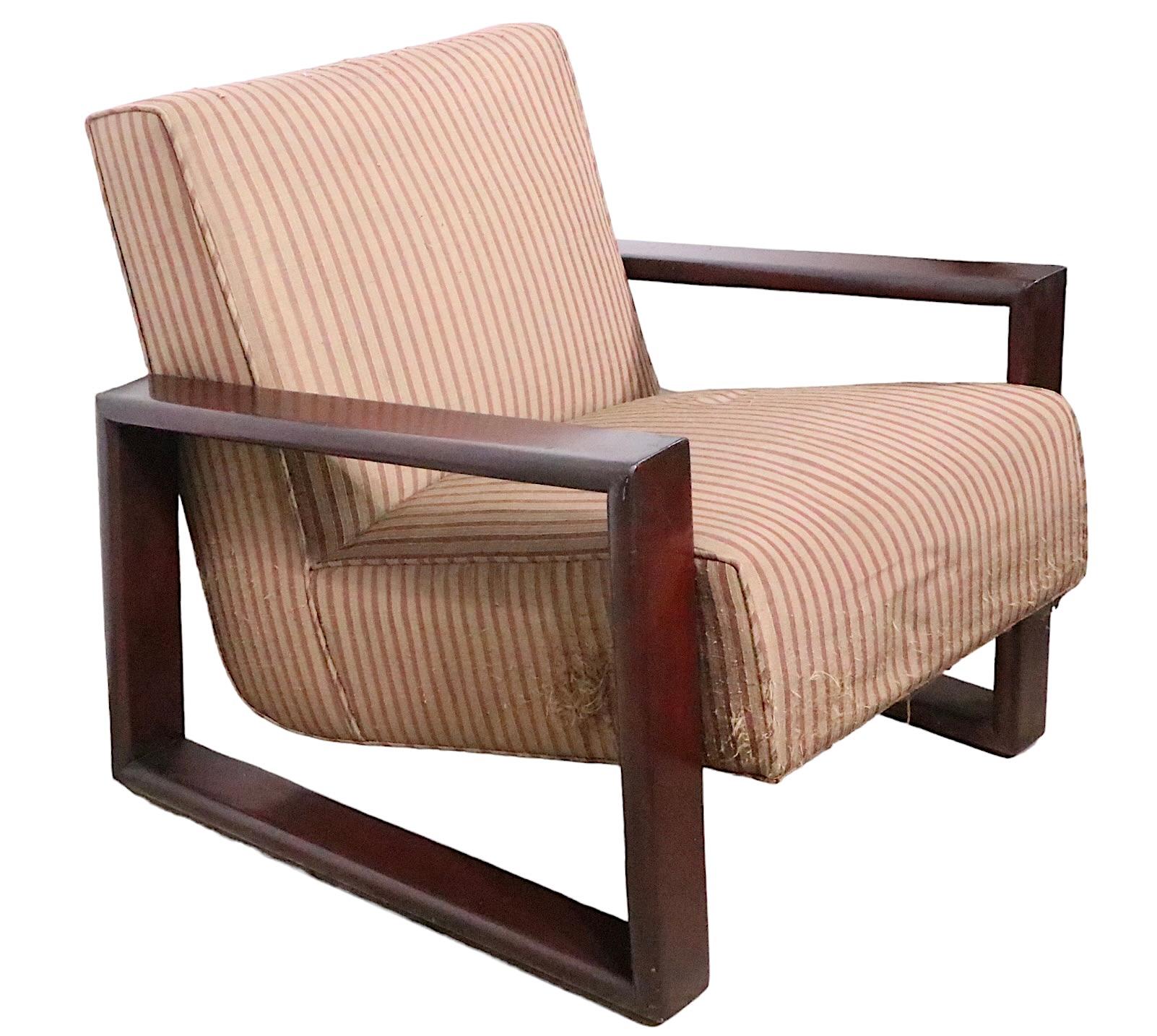 Pair of high style lounge chairs, with an architectural  continuous open arm and leg structure, which supports the upholstered seat and back. The chairs are structurally sound and sturdy, both will need to be refinished, and reupholstered. 
