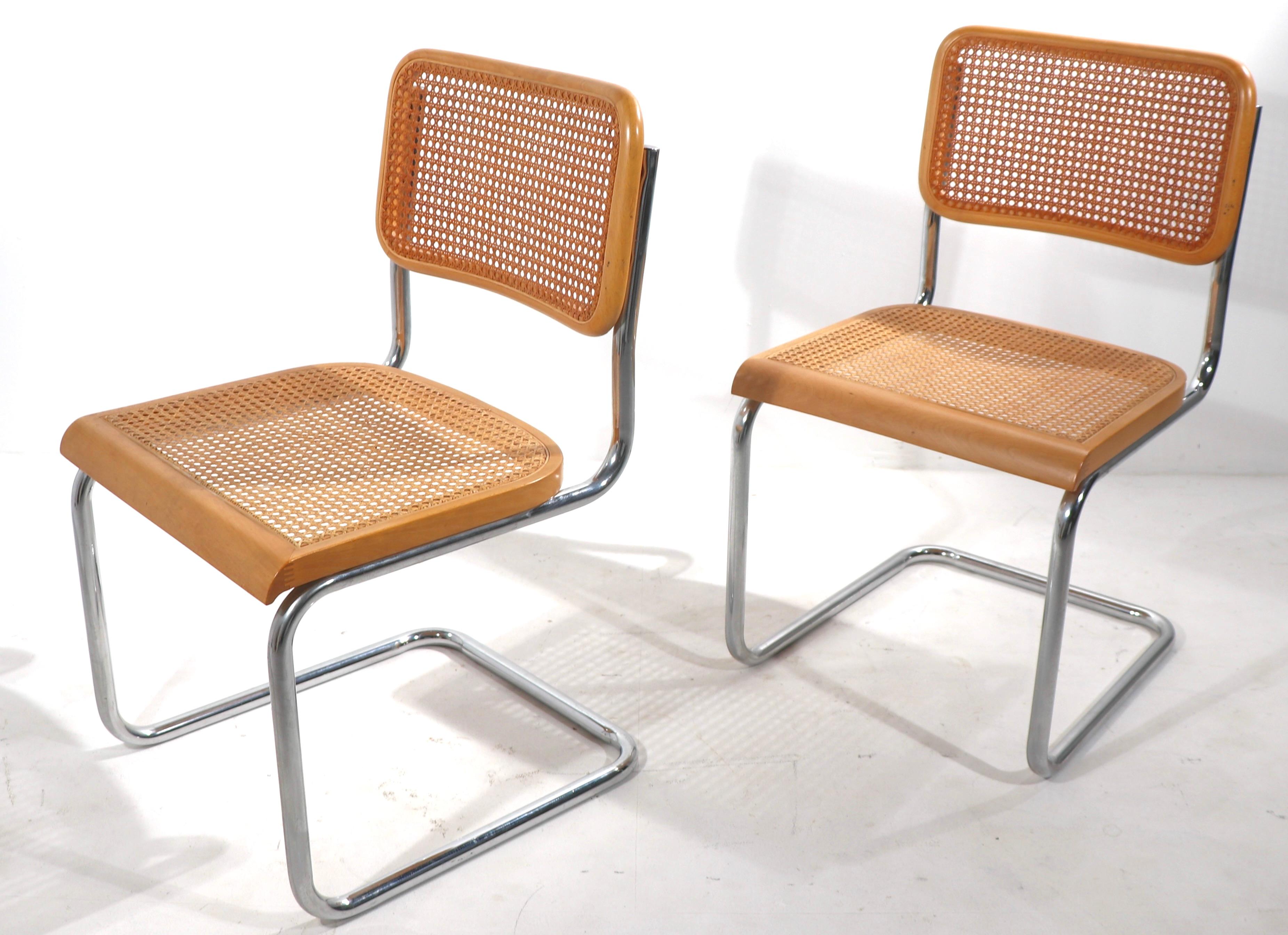 Nice pair of Marcel Breuer designed cantilevered dining height chairs, having beech wood and caned seat and back rests, on cantilevered chrome continuous leg frames. The chairs are in clean, original, estate condition, showing only light cosmetic