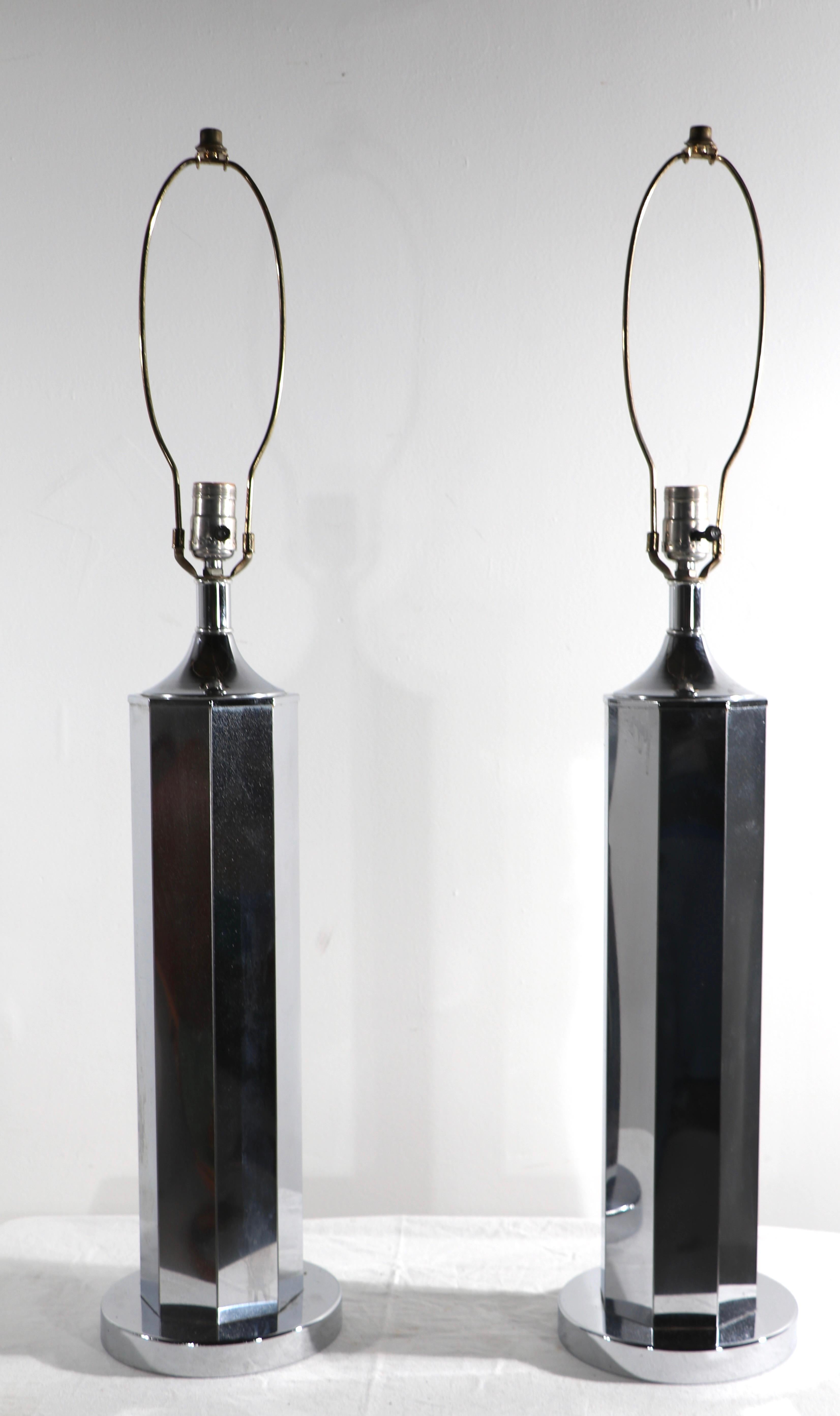 Pr. chrome table lamps circa 1970’s attributed to Sonneman Lighting. The chrome body is suggestive of a pencil in form, on round disk form base. Both show minor wear to the chrome finish, normal and consistent with age, both are clean and working,