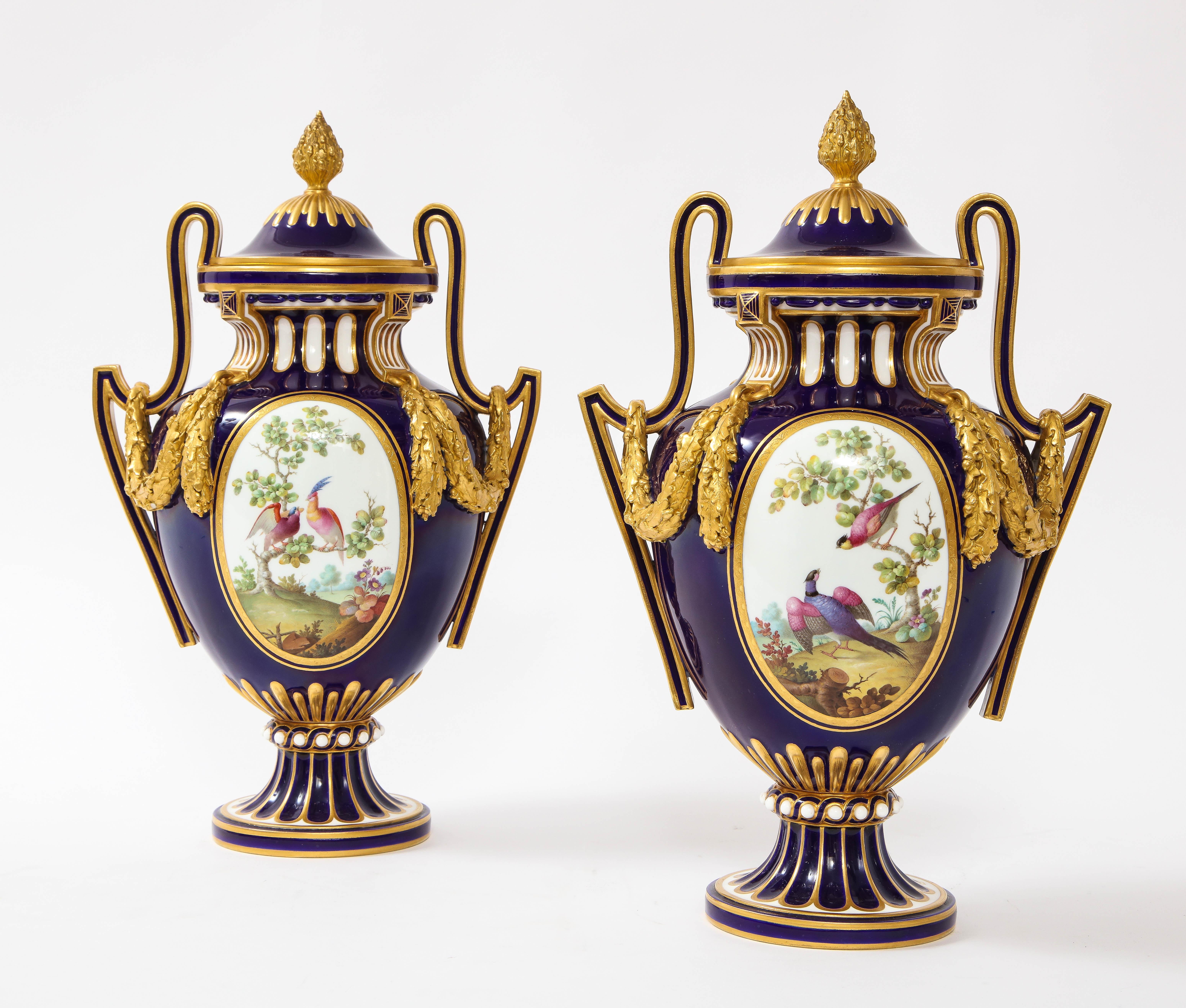 Une fantastique et belle paire de vases couverts de forme ovale en porcelaine anglaise de style Louis XVI, de style Sèvres, à fond bleu nouveau, peints et dorés à la main. Ces vases Mintons sont vraiment remarquables. De forme ovale avec un