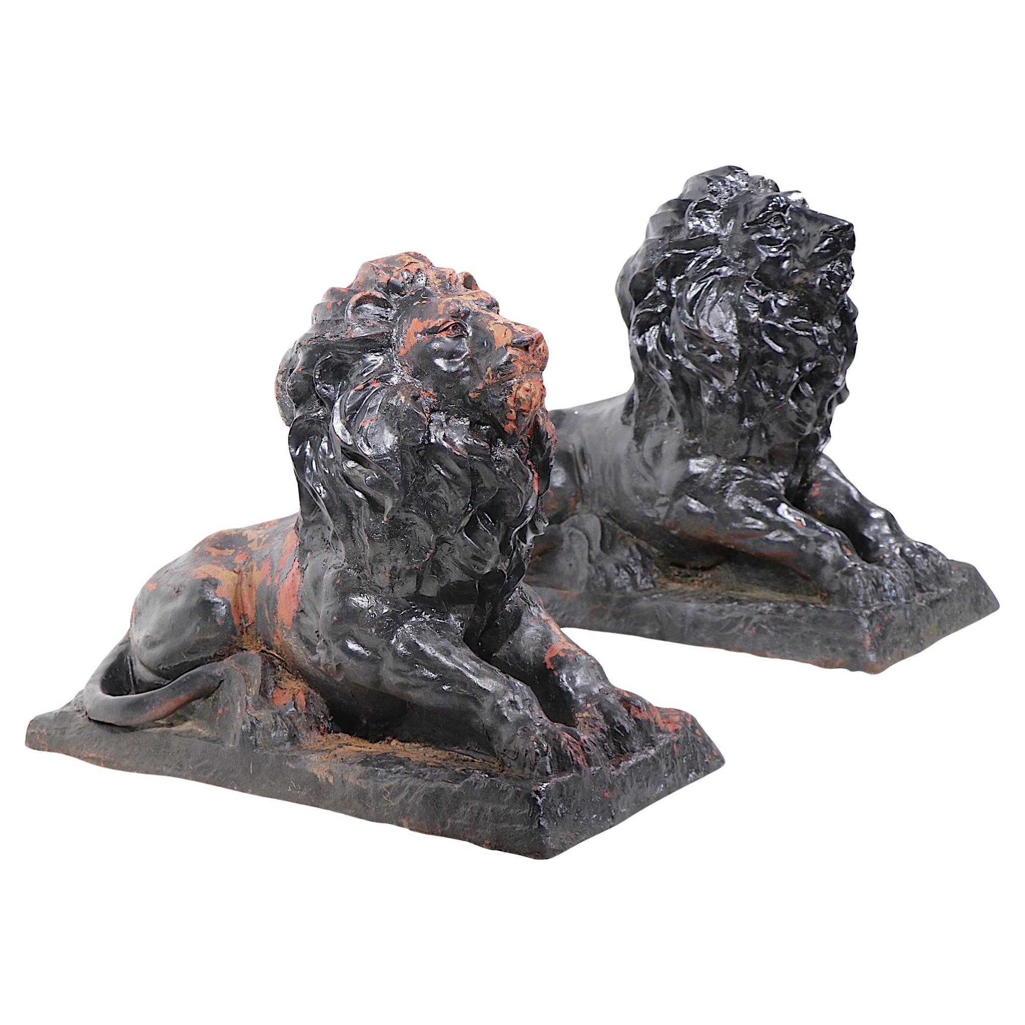 Classic pair of 19th C.  cast iron seated lions, in very good vintage estate condition. The lions are constructed of several pieces, typical of early production, both are free of later welds, repairs or damage, both have several coats of paint,