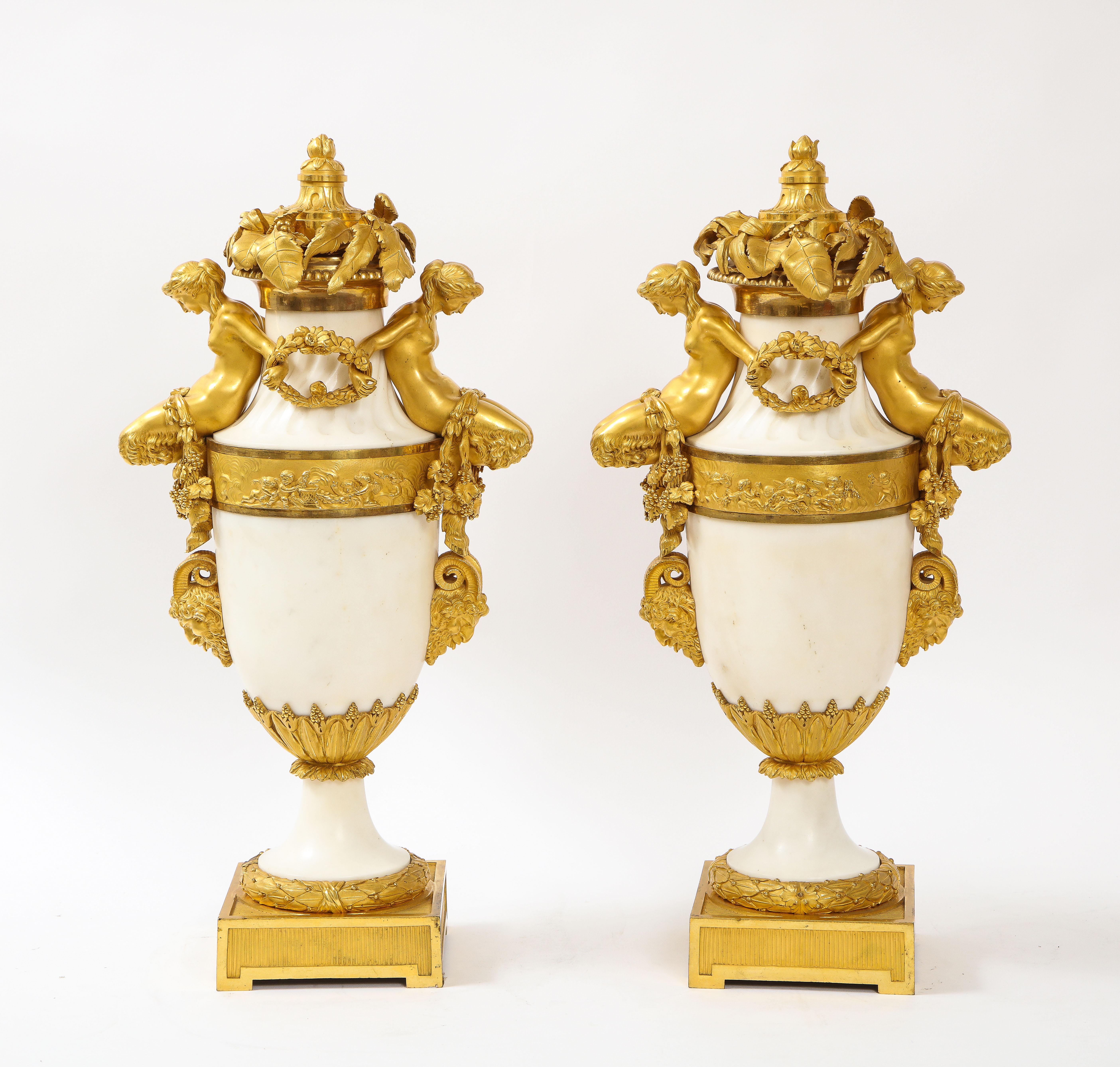 A Marvelous Pair of 19th Century Louis XVI Style French Dore Bronze Mounted White Carrara Marble Covered Urns/Covered vases, attributed to Henry Dasson. Each vase is beautifully hand-made with hand-carved Carrara marble bodies with fluted marble