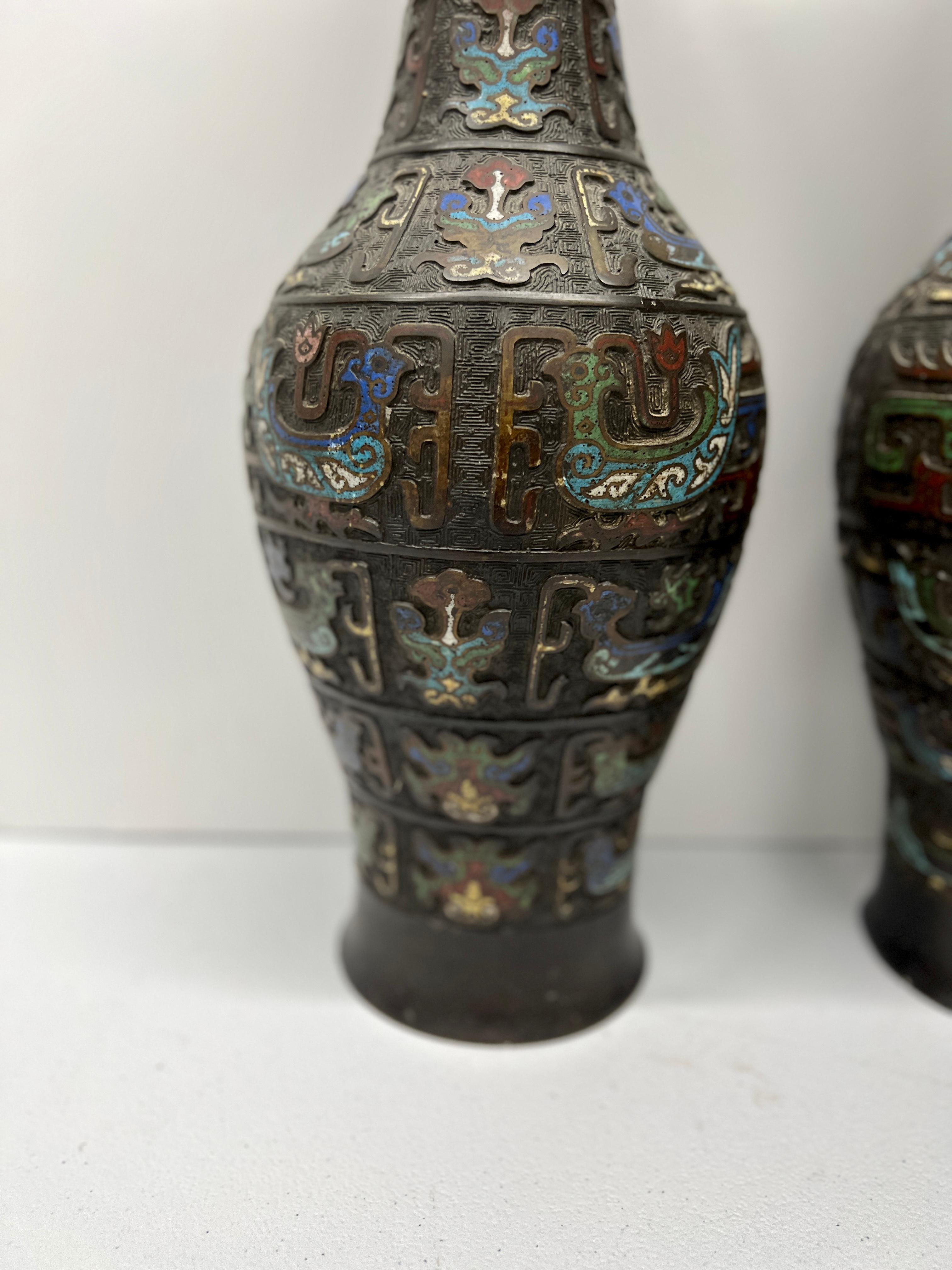 Giapponese, XIX secolo.

Questa squisita coppia di vasi giapponesi del XIX secolo in stile Champlevé o cloisonne con inserti in bronzo rappresenta una miscela magistrale di arte e artigianato. Ogni vaso è alto ben 21,25 pollici ed è ornato da un