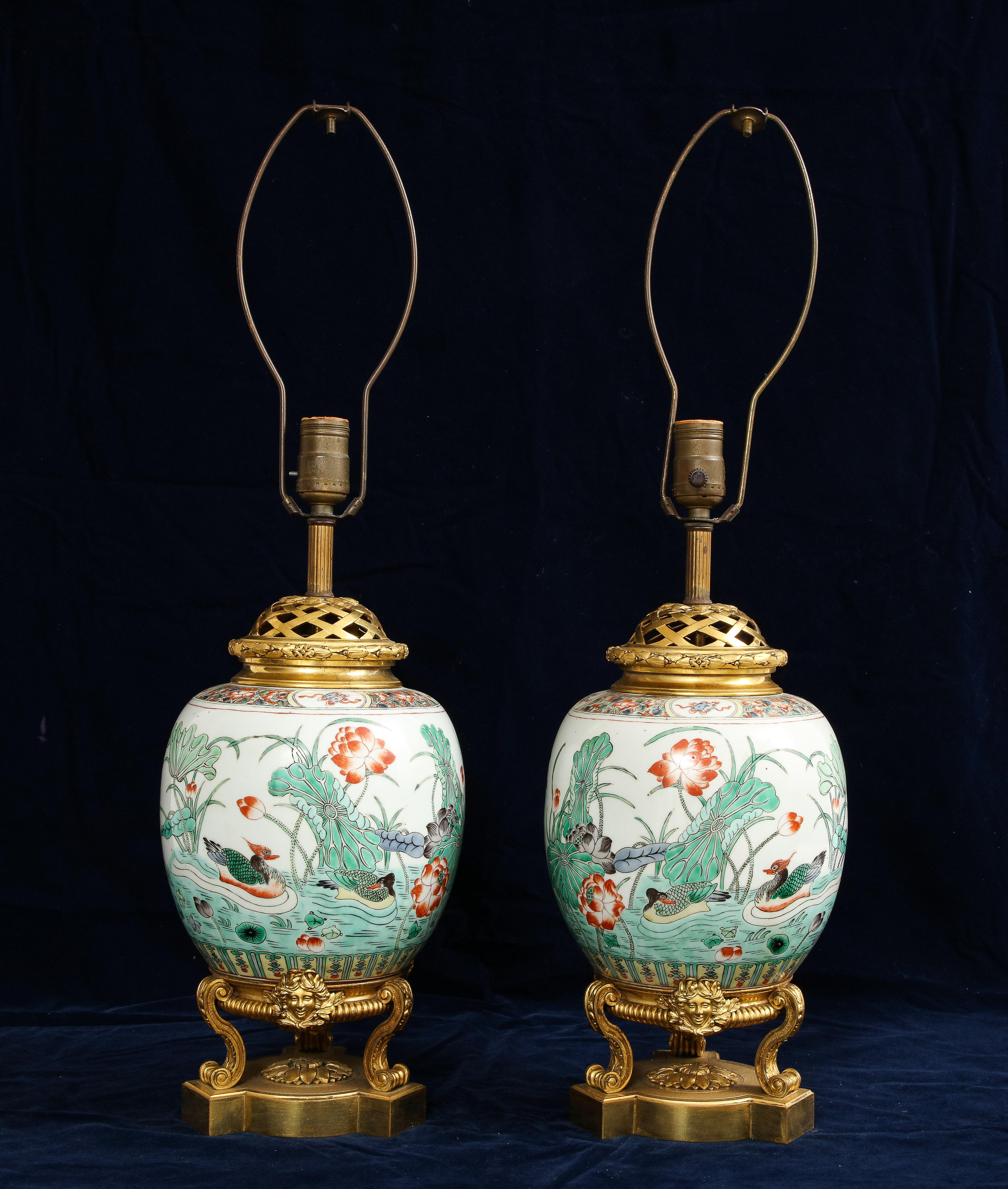 Magnifique paire de vases en porcelaine de famille verte chinoise de style Louis XVI du XIXe siècle, montés en bronze doré et transformés en lampes. Le bronze doré est attribué à Henry Dasson. Les vases en porcelaine chinoise montés sur bronze doré