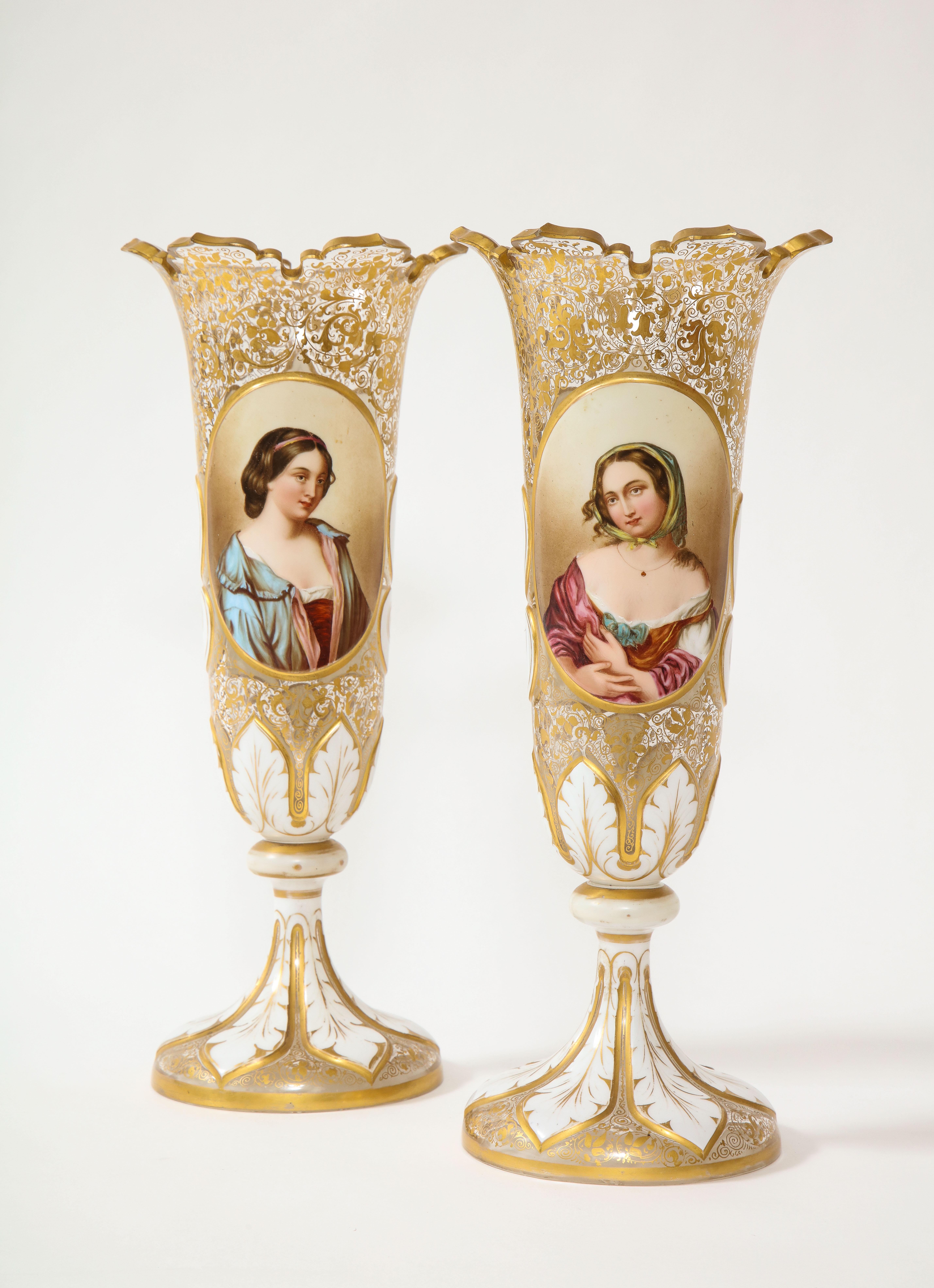 A pair of 19th century Louis XVI style Bohemian white over clear crystal maiden portrait vases with hand-painted gilt décor. Each is beautifully hand-painted with gorgeous maidens looking at one another. Each maiden is beautifully hand-painted with