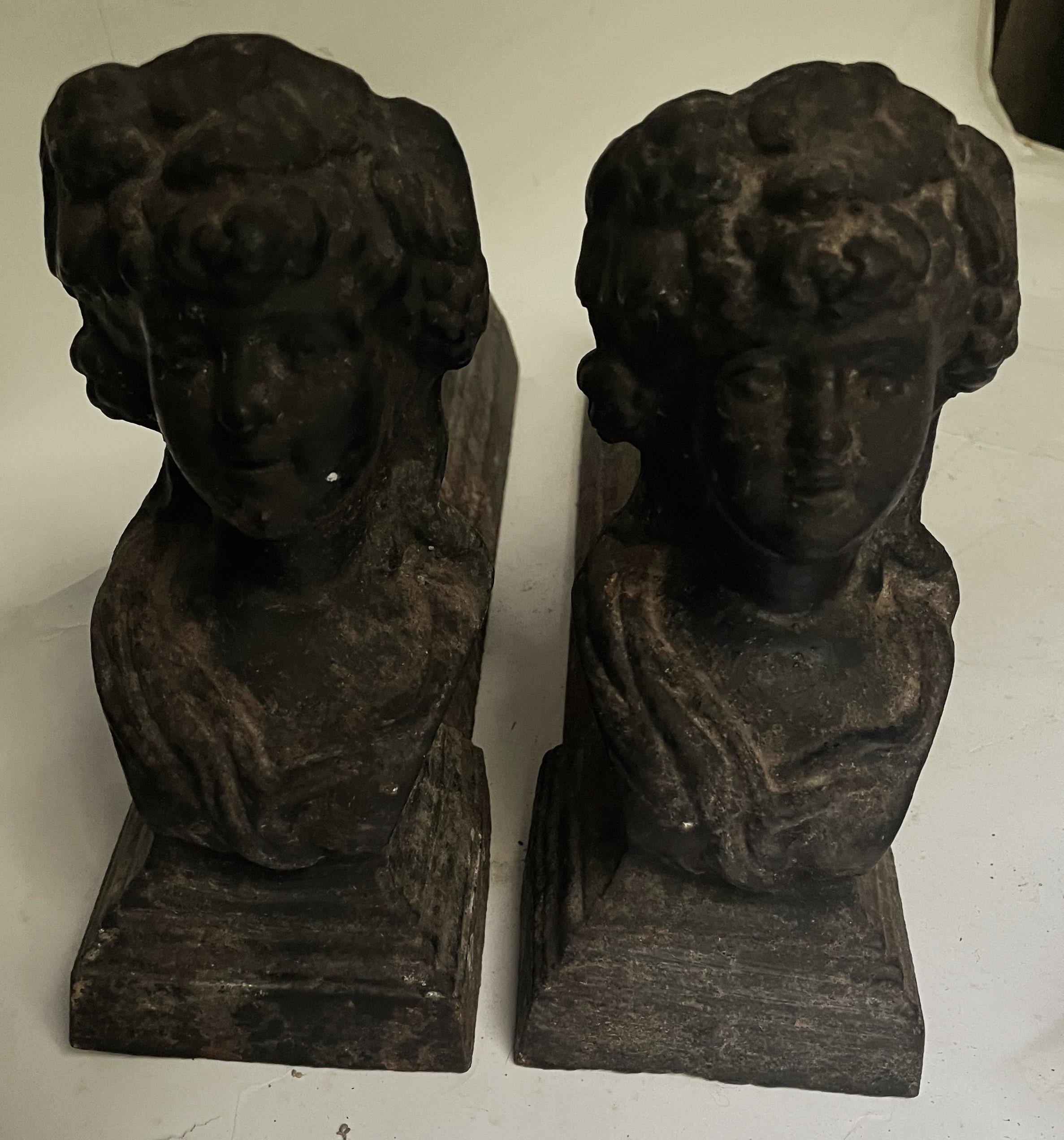 Voici une paire de chenets de cheminée ou chiens de feu en fonte absolument charmante et adorable, avec le buste d'une jeune femme séduisante, ses cheveux bouclés relevés en chignon. La finition peinte en noir a vieilli et présente une magnifique