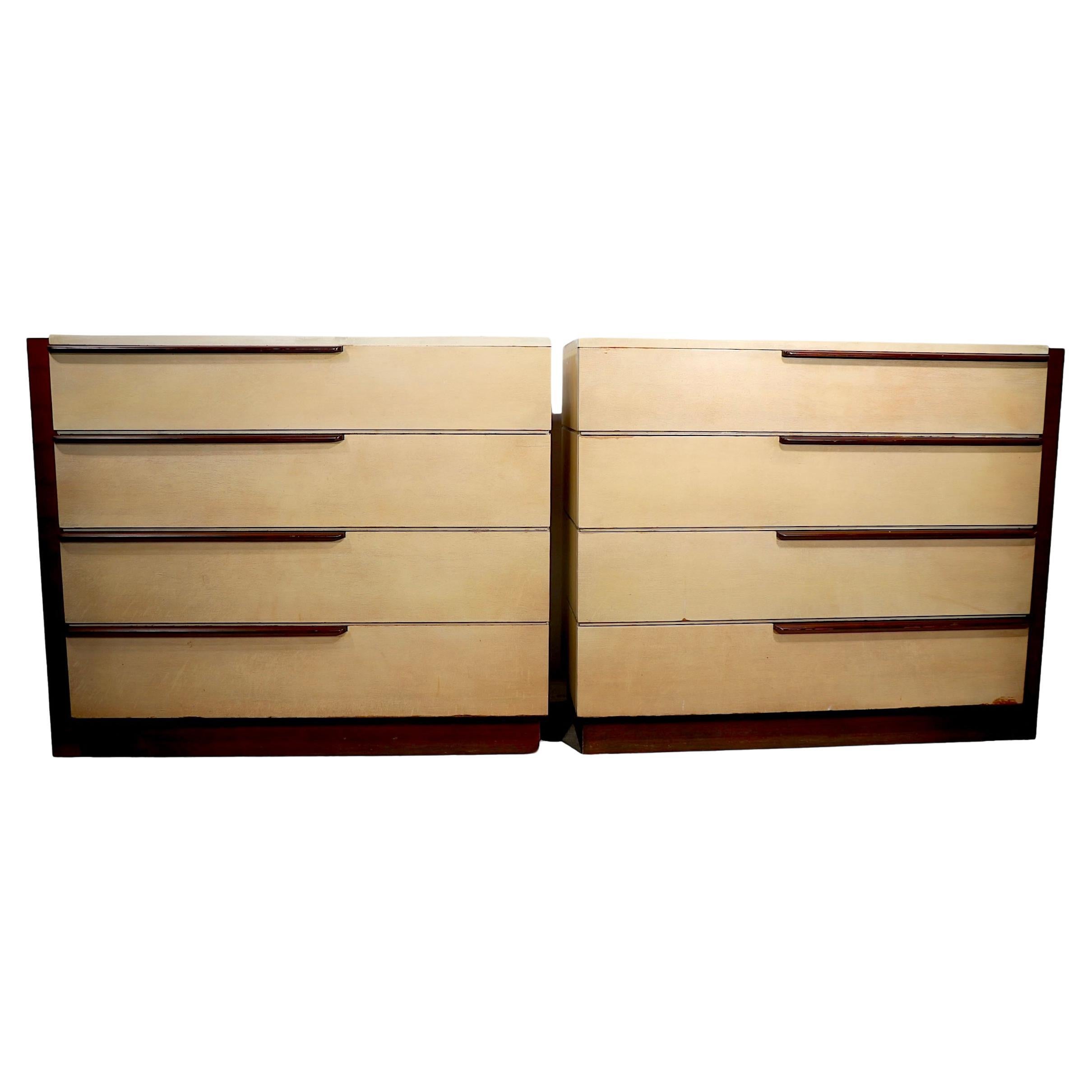 Chic pair of streamline Art Moderne dressers designed by Gilbert Rohde, for Herman Miller c 1936. The dressers feature opposing right and left cases, each with pale yellow drawer fronts and tops, with contrasting walnut framing, and drawer pulls. We