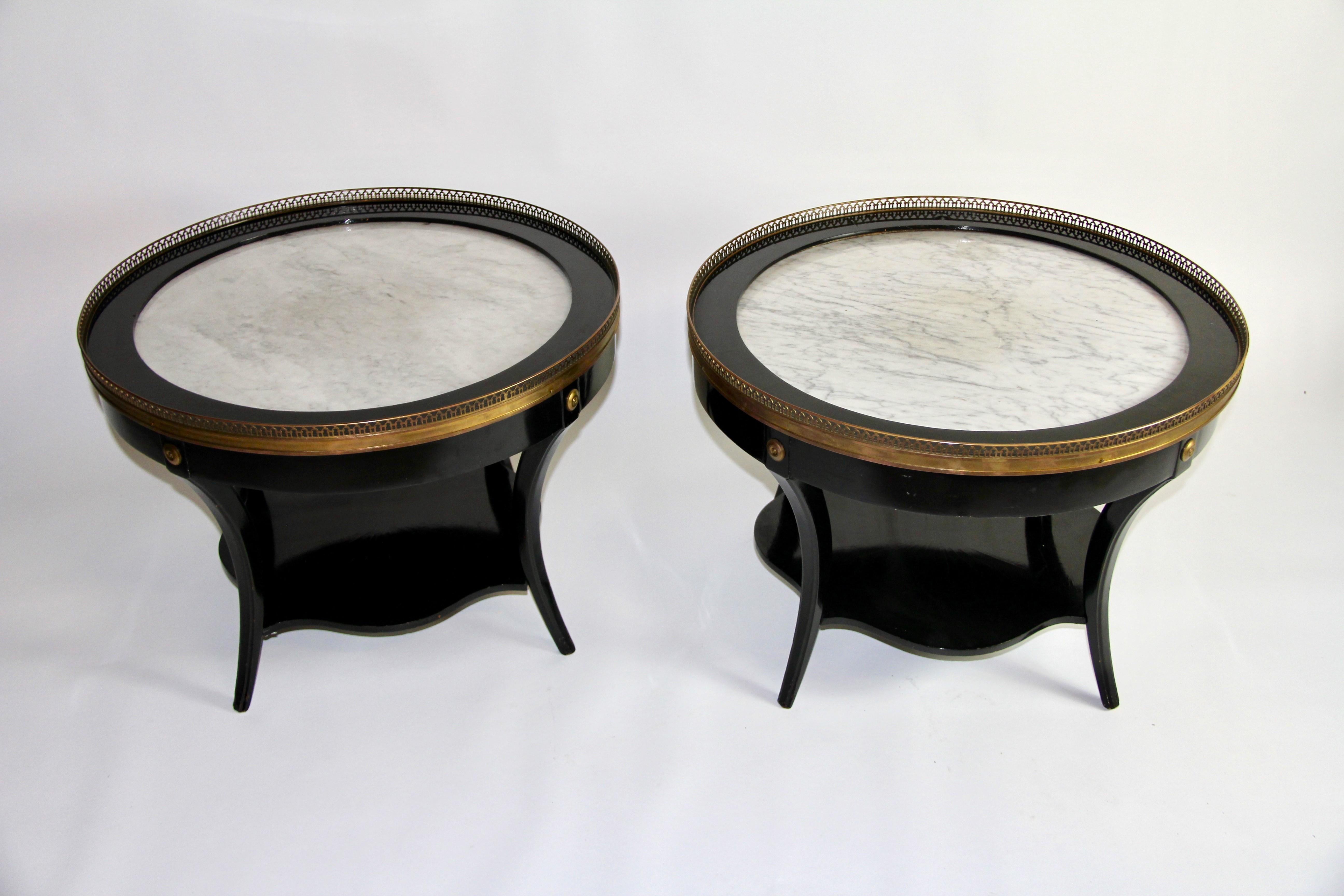 A Fantastic Pair of Art Deco Gilt Bronze Mounted Black Lacquer Marble Top Side Tables/Coffee Tables, Attributed to Jansen. Each table features black-lacquered  wooden bases, white marble tops, and bronze mounts. They consist of round marble insert