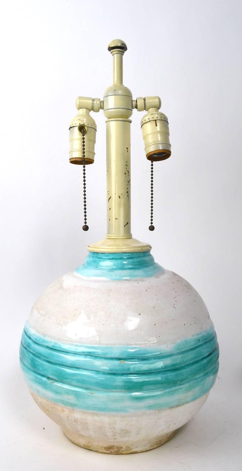 Wonderful pair of ball form Art Deco pottery lamps marked France dore, 1928. Both are in excellent original, working condition, with off-white glaze and turquoise banding in the centre.