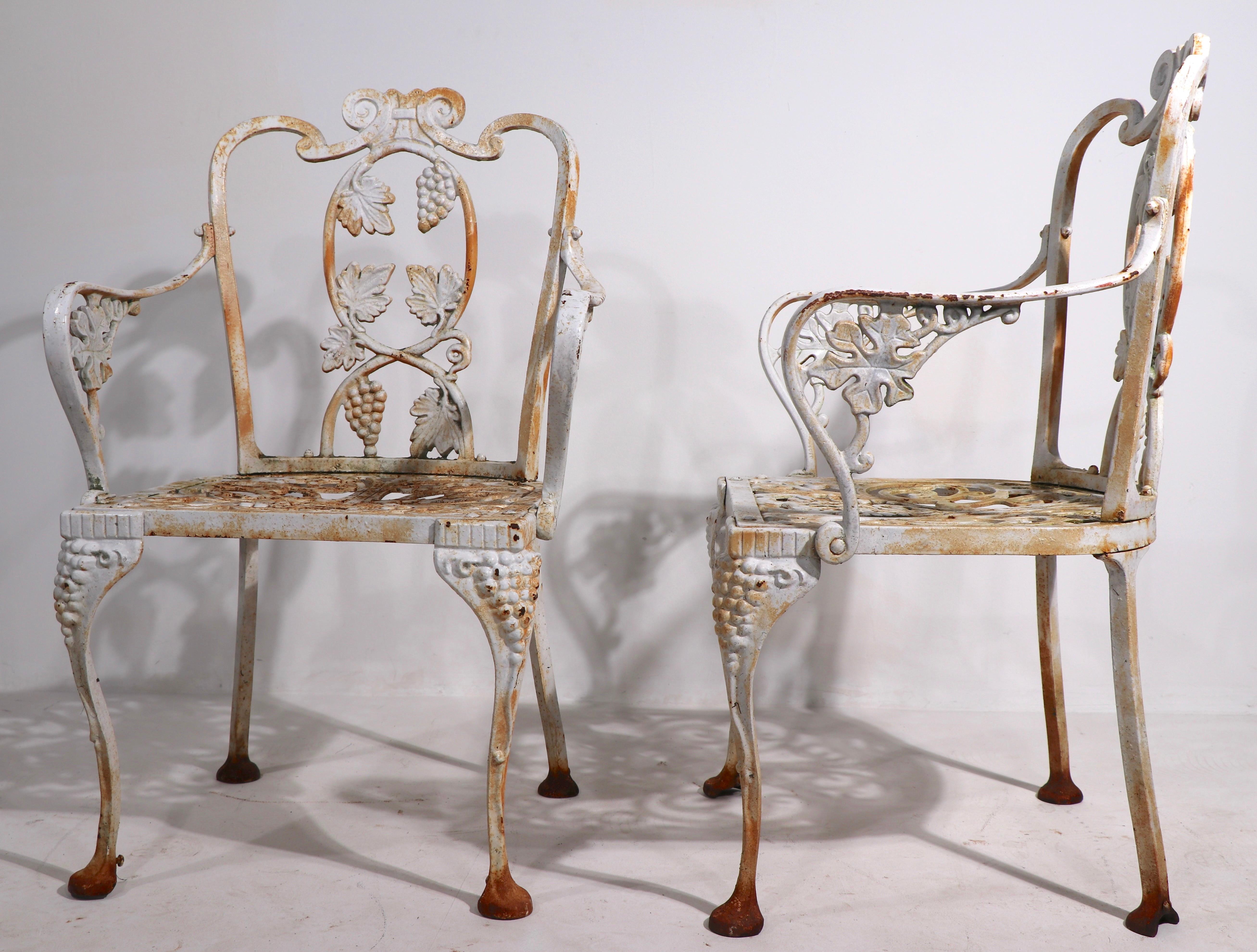 Ornate pair of cast iron garden chairs by Atlanta Stove Works, 20th century vintage in the 19th century style. Both are in very good condition, showing cosmetic wear to finish normal and consistent with age. Offered and priced as a pair. 
       