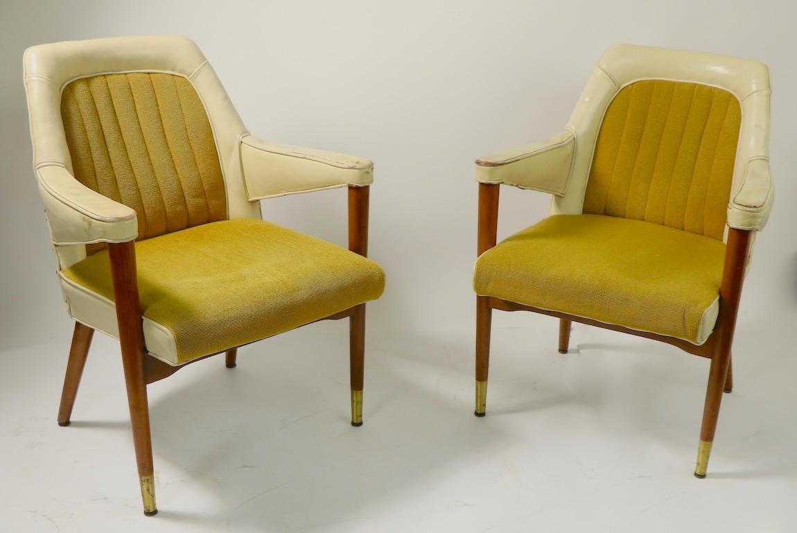 Pair of leather and fabric armchairs with tapered pole wood legs, by the B L Marble Chair Company. The chairs have cream colored leather sides with channeled mustard upholstered backrests and seats. Wonderful design, chic, stylish and hip