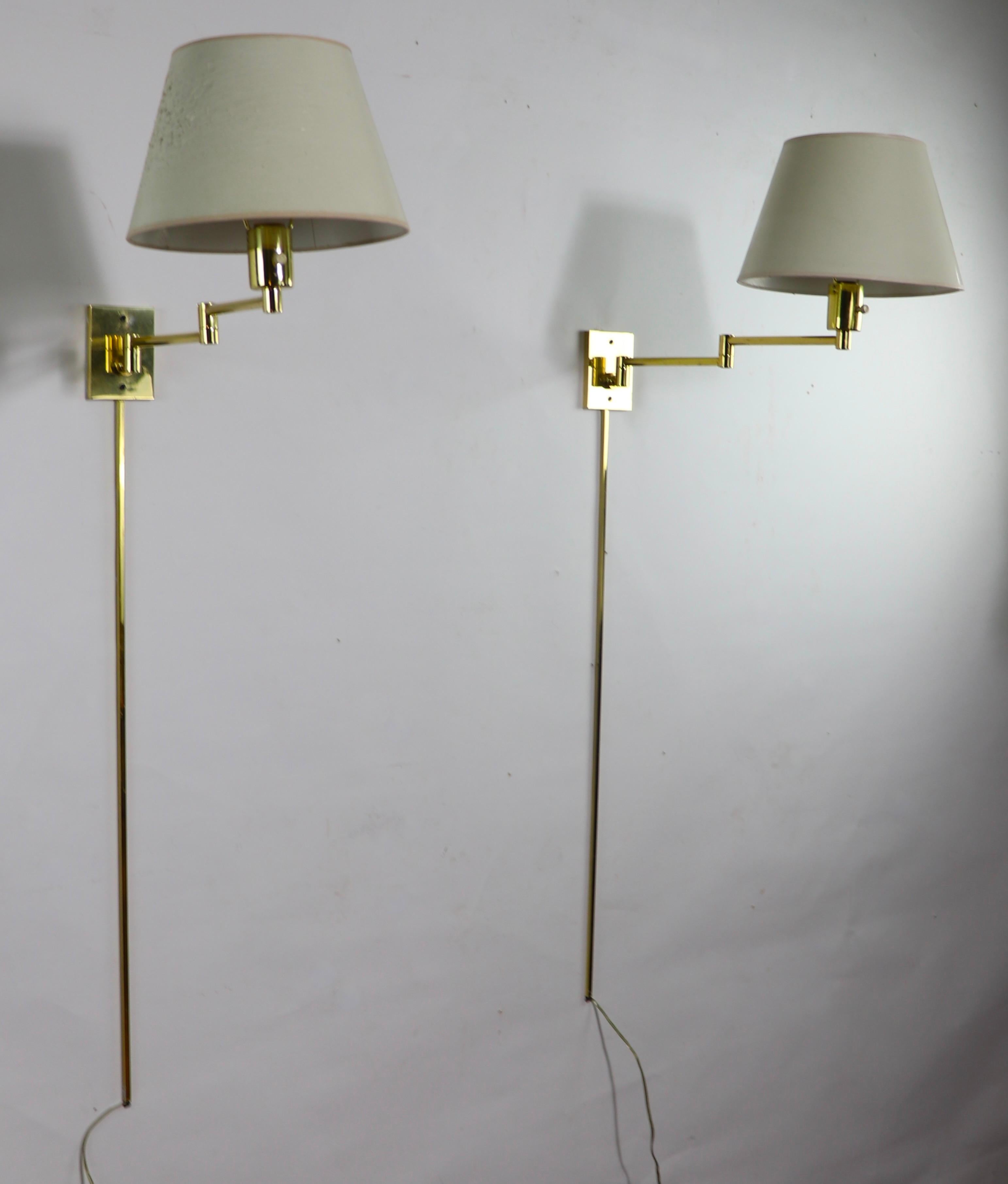 Elegant, sophisticated, and chic, this pair of solid brass wall m mount sconces feature a jointed flex arm, which is mounted to a rectangular brass faceplate, which attaches to the wall. Extending down from the faceplate are the original brass wire